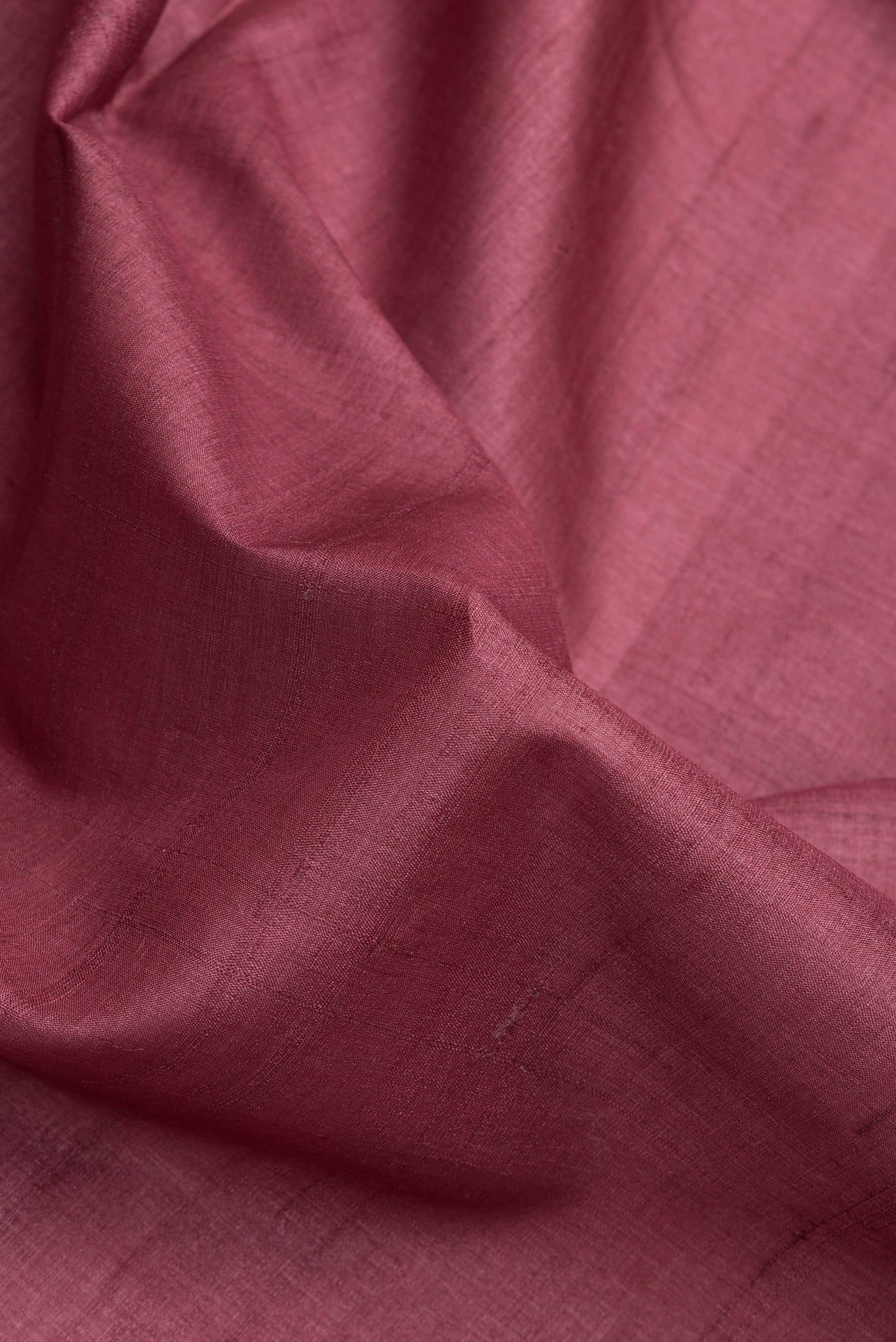Close up of Maroon Dual Tone Tussar Silk Saree with Plain Body and Fancy Border.  displaying folds
