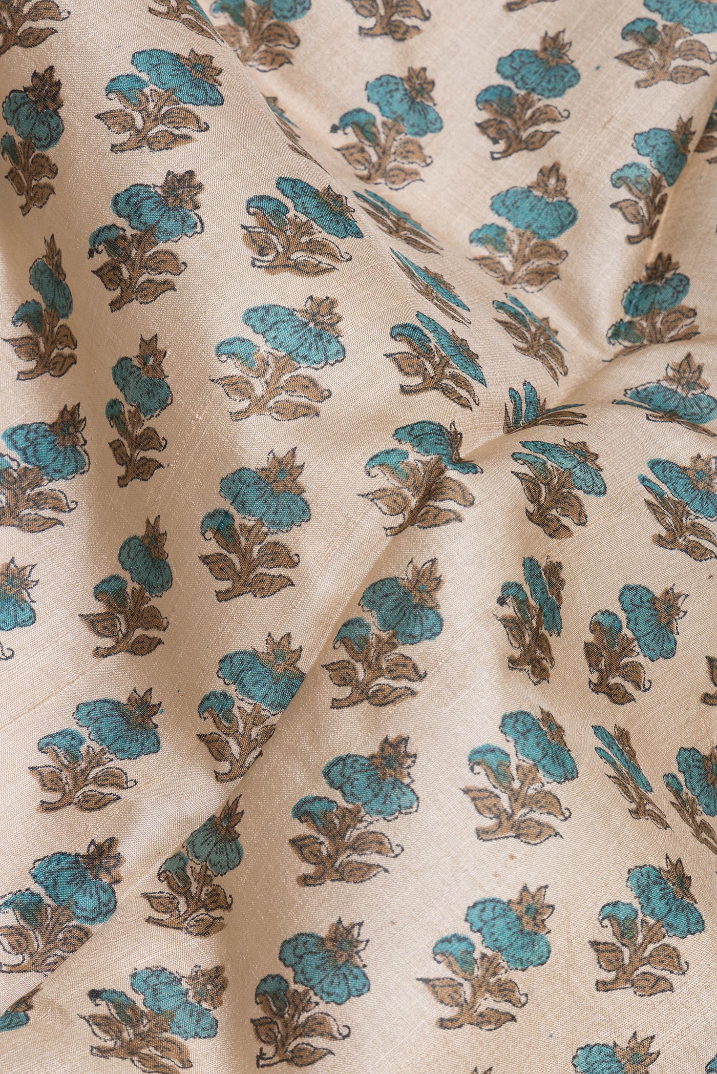 Close up of Beige Tussar Silk Saree with Printed design on the body and Fancy Border.  displaying folds