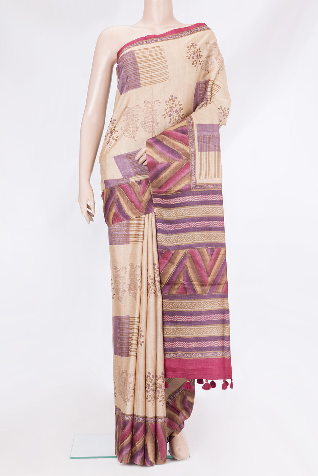 Beige Tussar Silk Saree with Printed design on the body and Fancy Border.  displayed on a mannequin