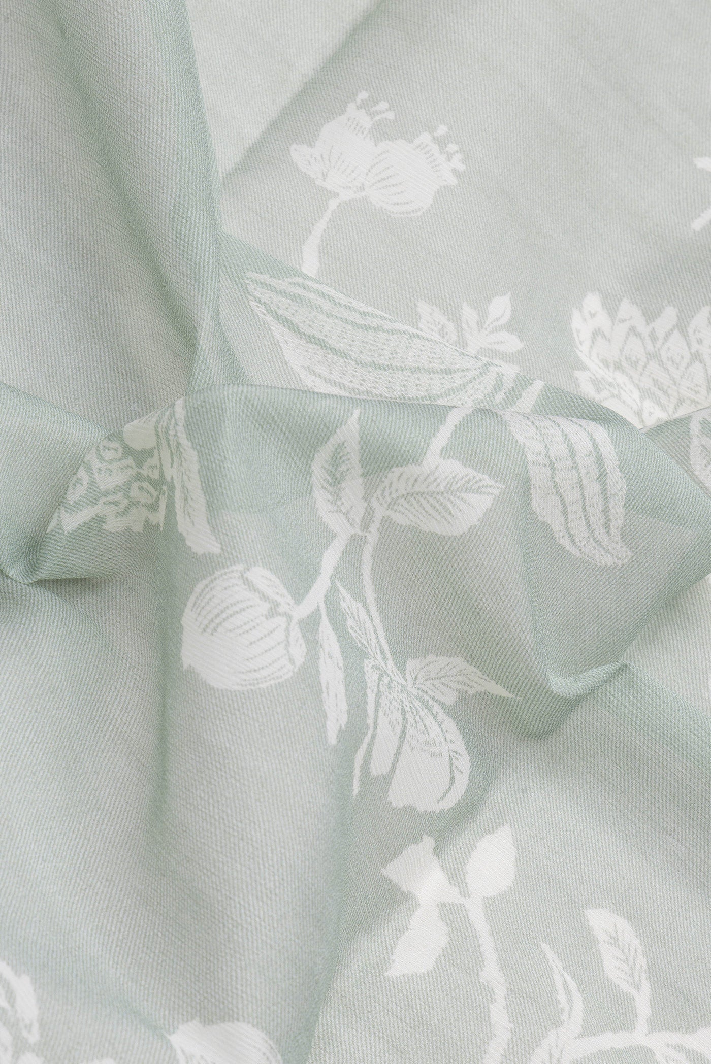 Close up of Light Green Mysore Chiffon Saree with Printed design on the body and Without Border.  displaying folds