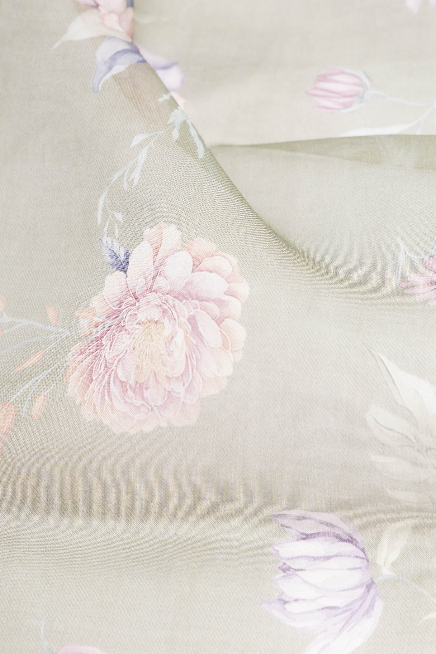 Close up of Sage Green Organza Silk Saree with Floral Print on the body and Without Border.  displaying folds