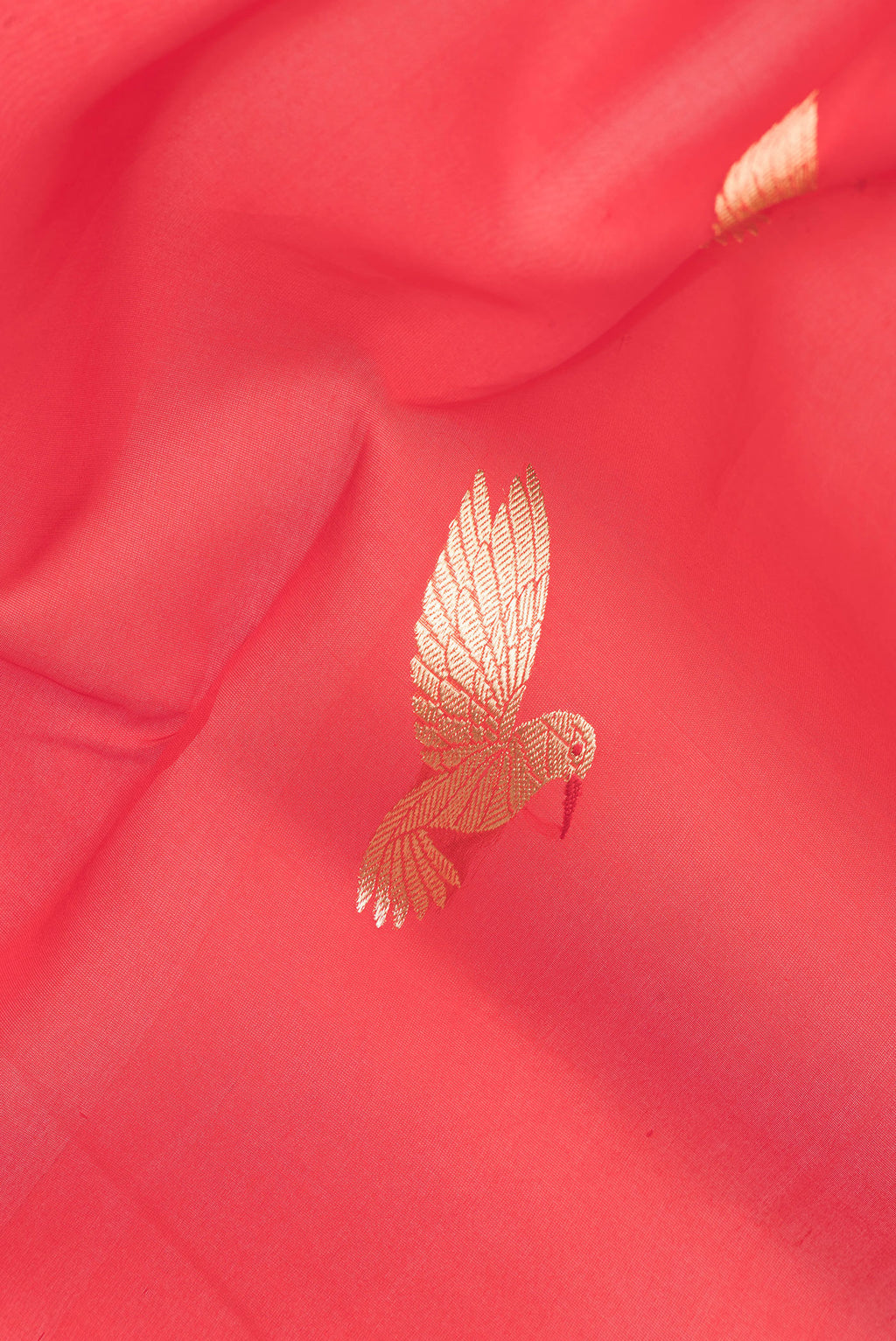 Close up of Pure Silk Red Dual Tone Tussar Saree with Zari Butta on the body and Zari Border.  displaying folds