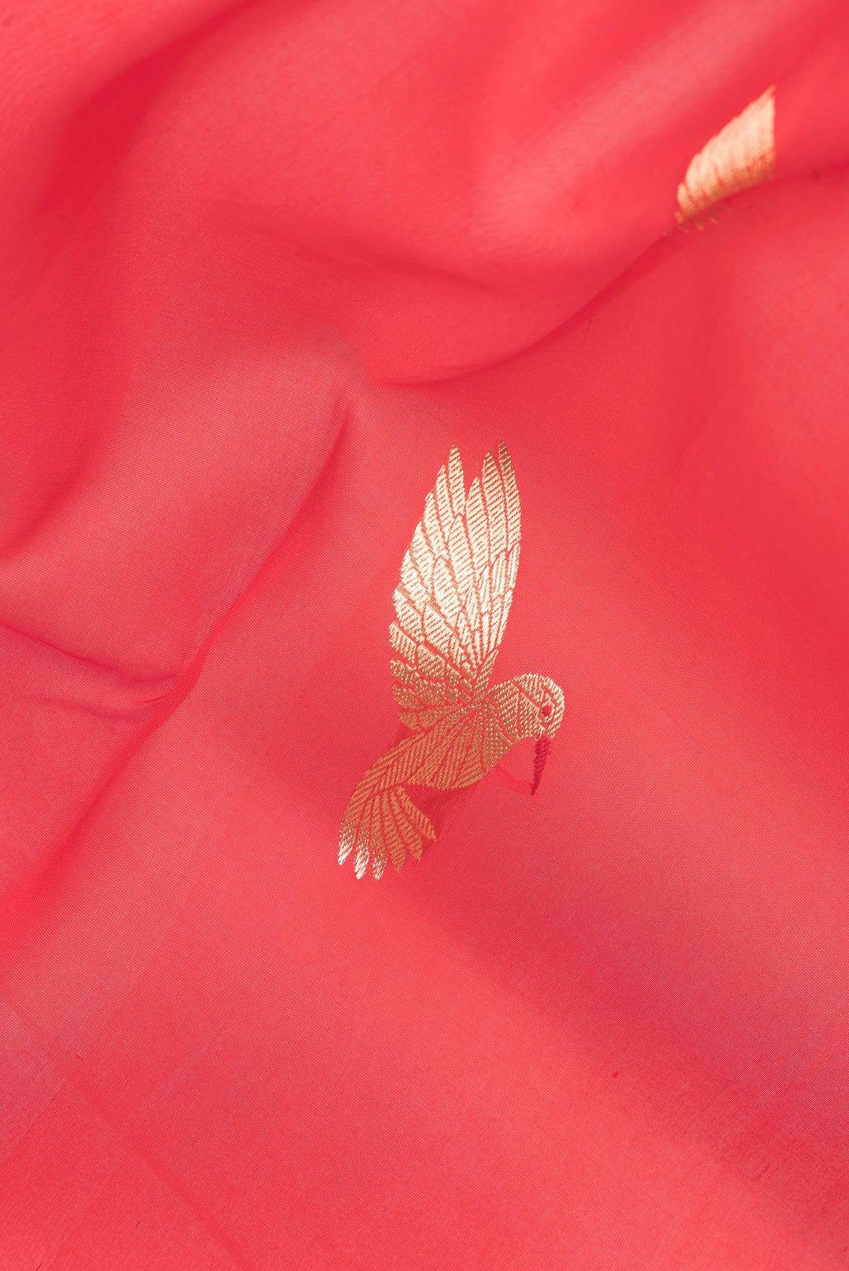 Close up of Pure Silk Red Dual Tone Tussar Saree with Zari Butta on the body and Zari Border.  displaying folds