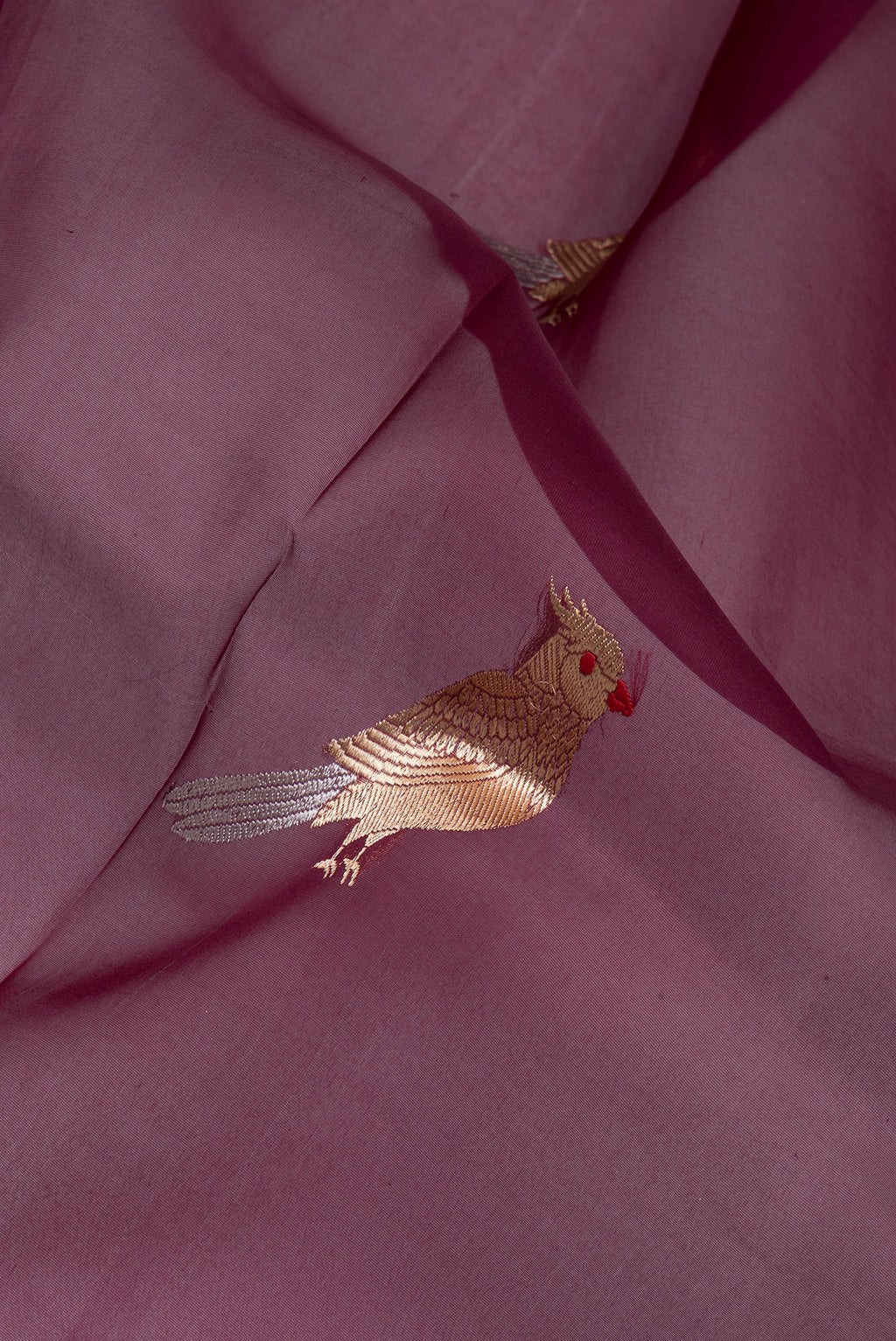 Close up of Maroon Organza Silk Saree with Zari Butta on the body and Zari Border.  displaying folds