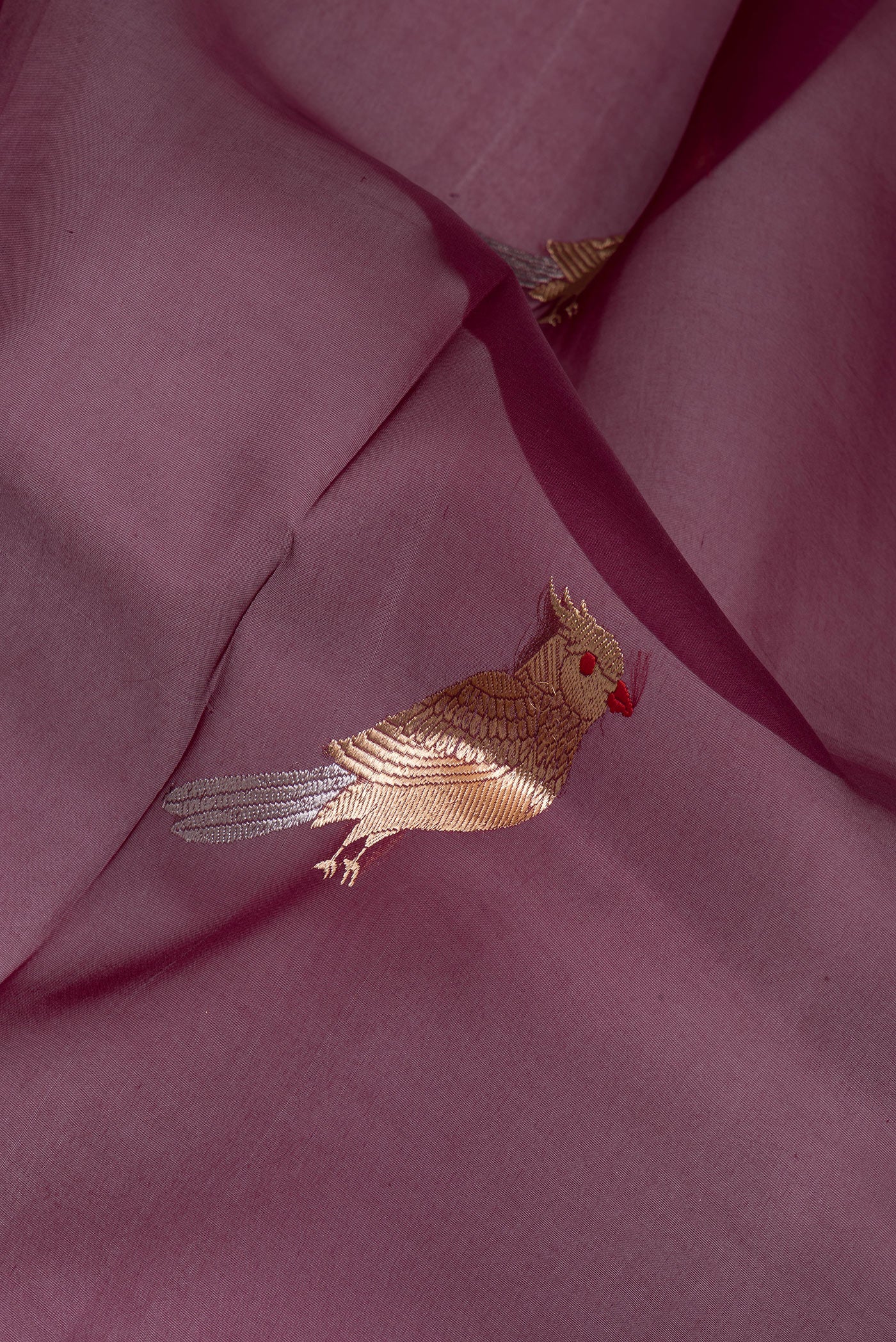 Close up of Maroon Organza Silk Saree with Zari Butta on the body and Zari Border.  displaying folds