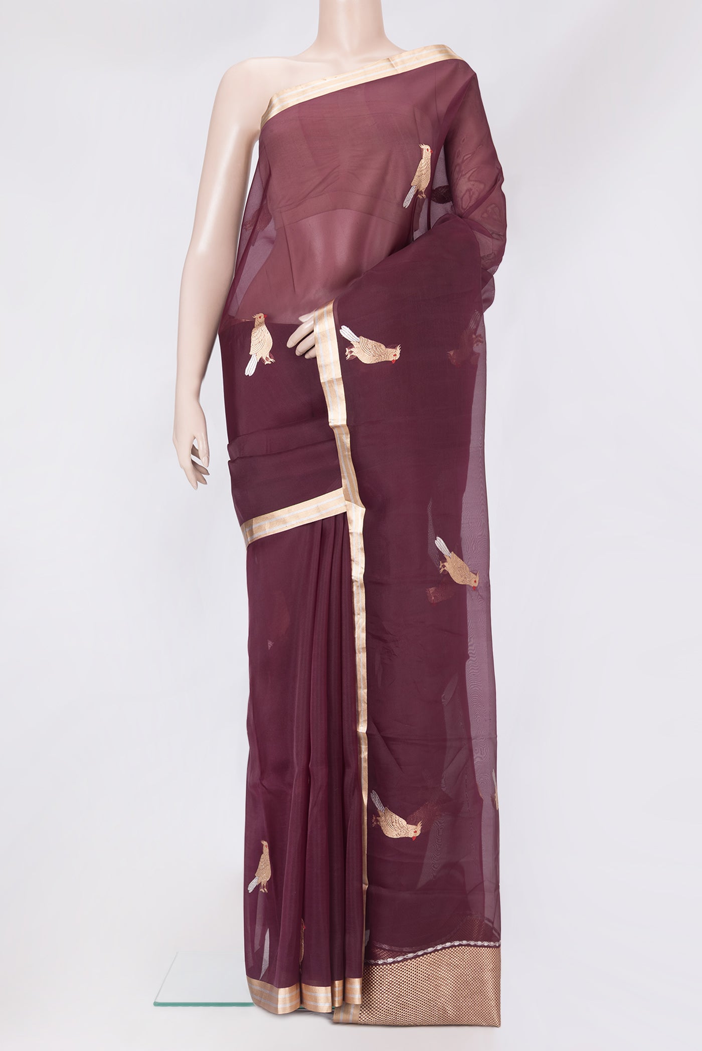 Maroon Organza Silk Saree with Zari Butta on the body and Zari Border.  displayed on a mannequin