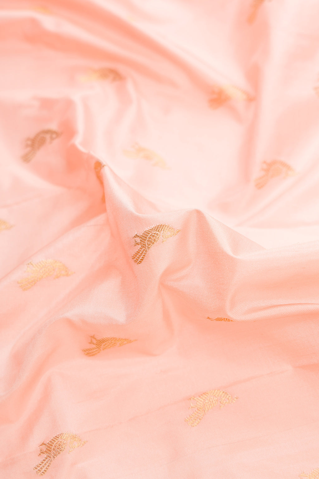 Close up of Peach Dual Tone Paithani Silk Saree with Zari Butta on the body and Paithani Border.  displaying folds