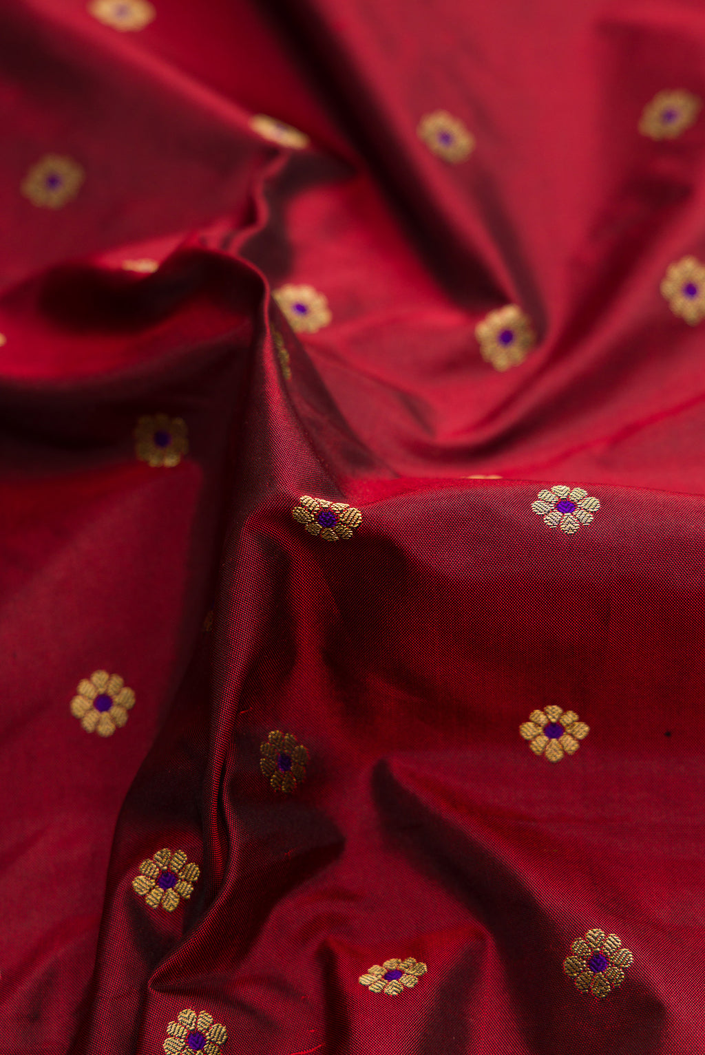 Close up of Maroon Dual Tone Paithani Silk Saree with Zari Butta on the body and Paithani Border.  displaying folds