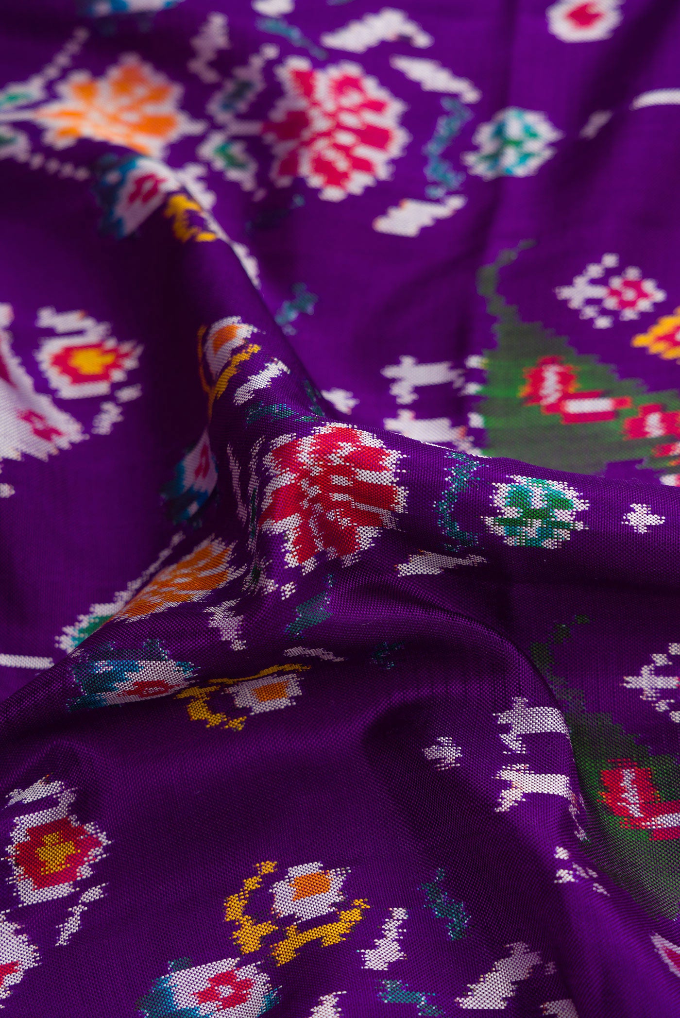 Close up of Violet Dual Tone Double Ikat Saree with Ikat Print on the body and Ikat Border.  displaying folds