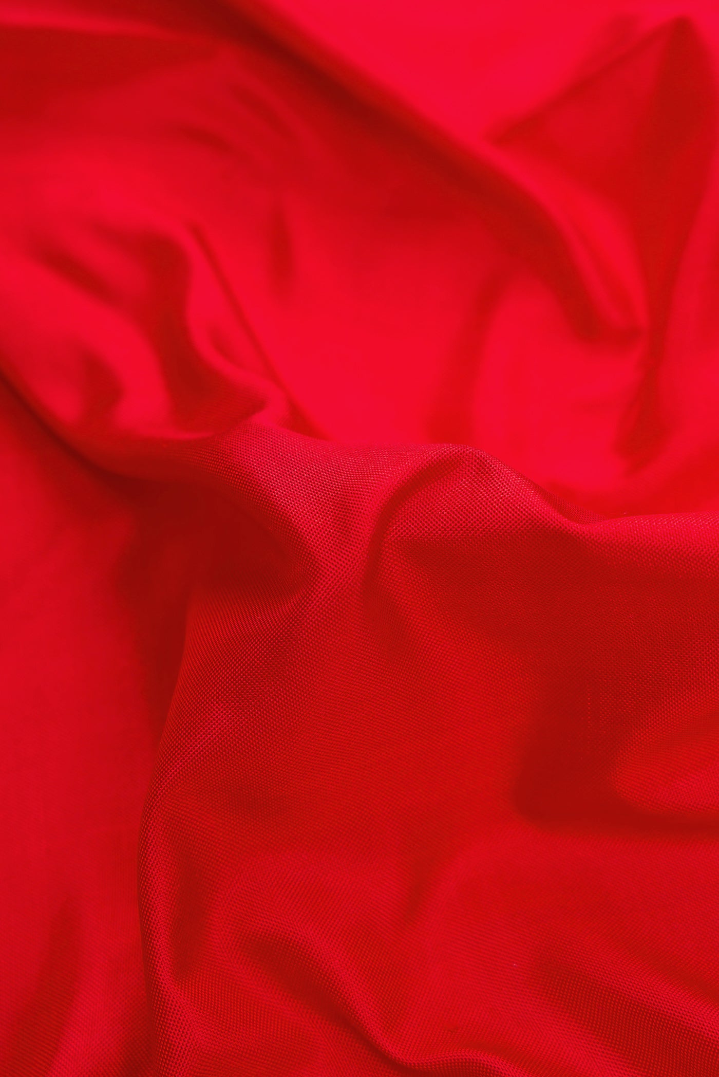 Close up of Red Dual Tone Double Ikat Saree with Plain Body and Ikat Border.  displaying folds