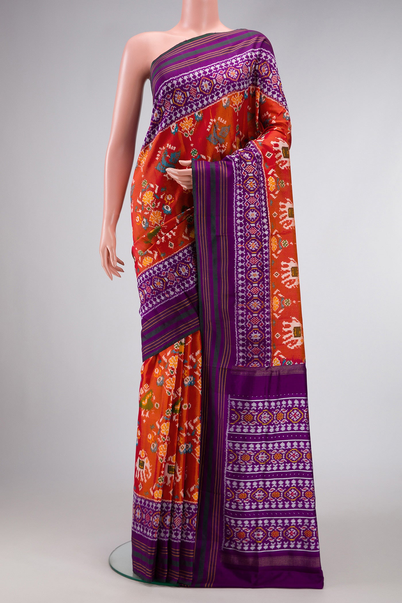 Brick Orange Dual Tone Double Ikat Saree with Ikat Print on the body and Zari Border.  displayed on a mannequin