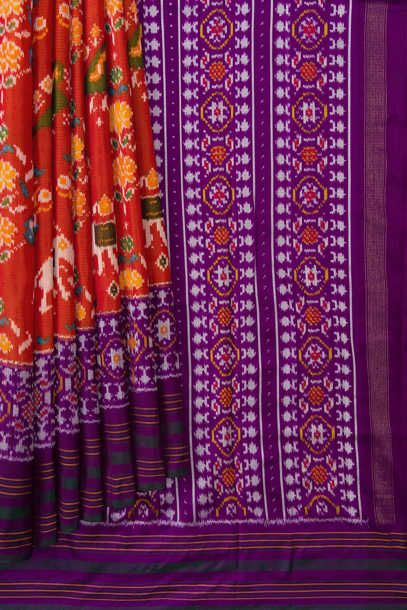 Pleats and pallu of Brick Orange Dual Tone Double Ikat Saree with Ikat Print on the body and Zari Border. 