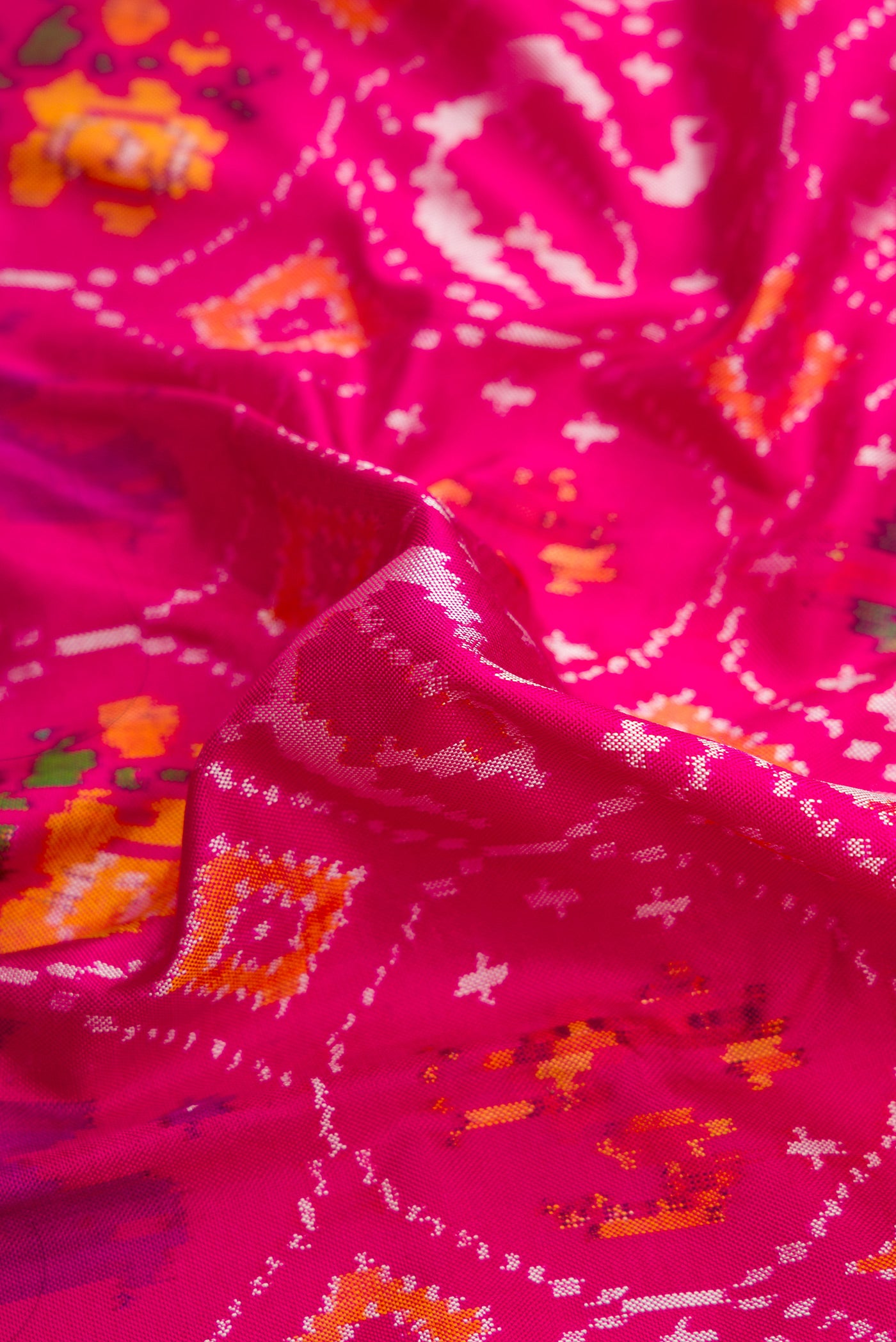 Close up of Pink Dual Tone Double Ikat Saree with Ikat Print on the body and Ikat Border.  displaying folds