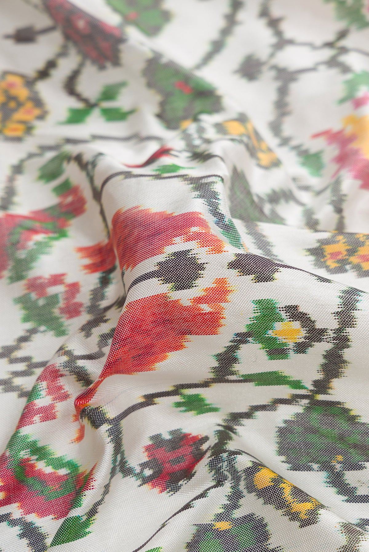 Close up of Off White Dual Tone Double Ikat Saree with Ikat Print on the body and Ikat Border.  displaying folds