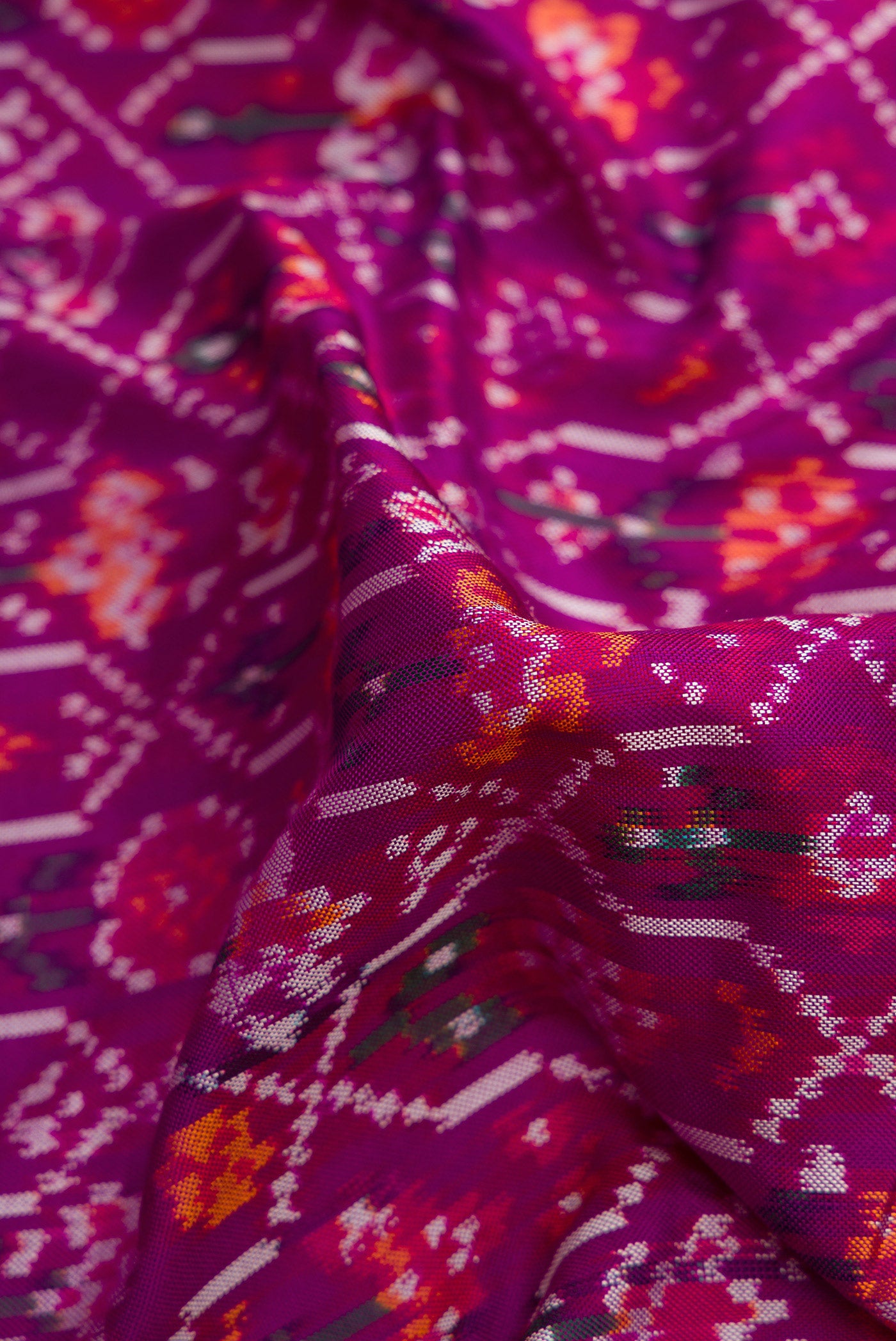 Close up of Purple Dual Tone Double Ikat Saree with Ikat Print on the body and Zari Border.  displaying folds