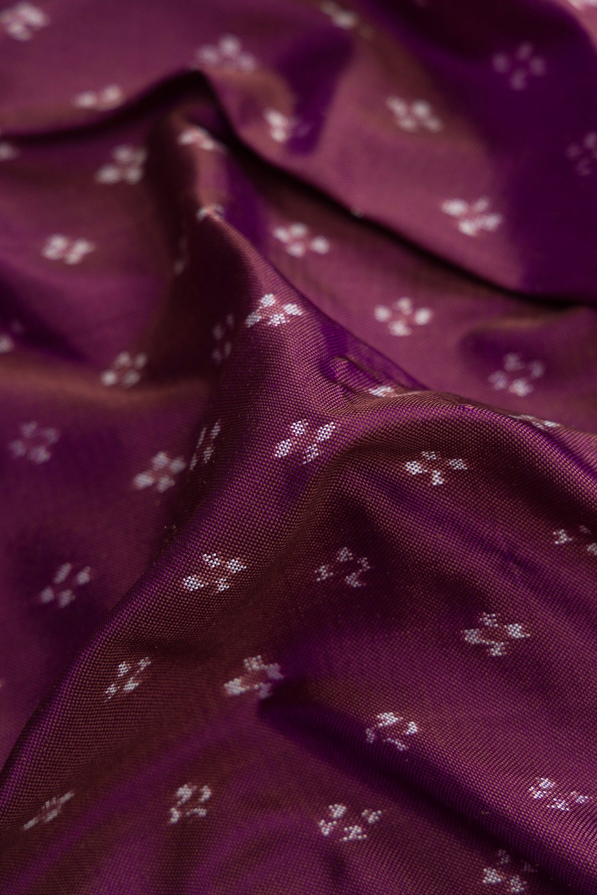 Close up of Purple Dual Tone Double Ikat Saree with Ikat Print on the body and Zari Border.  displaying folds