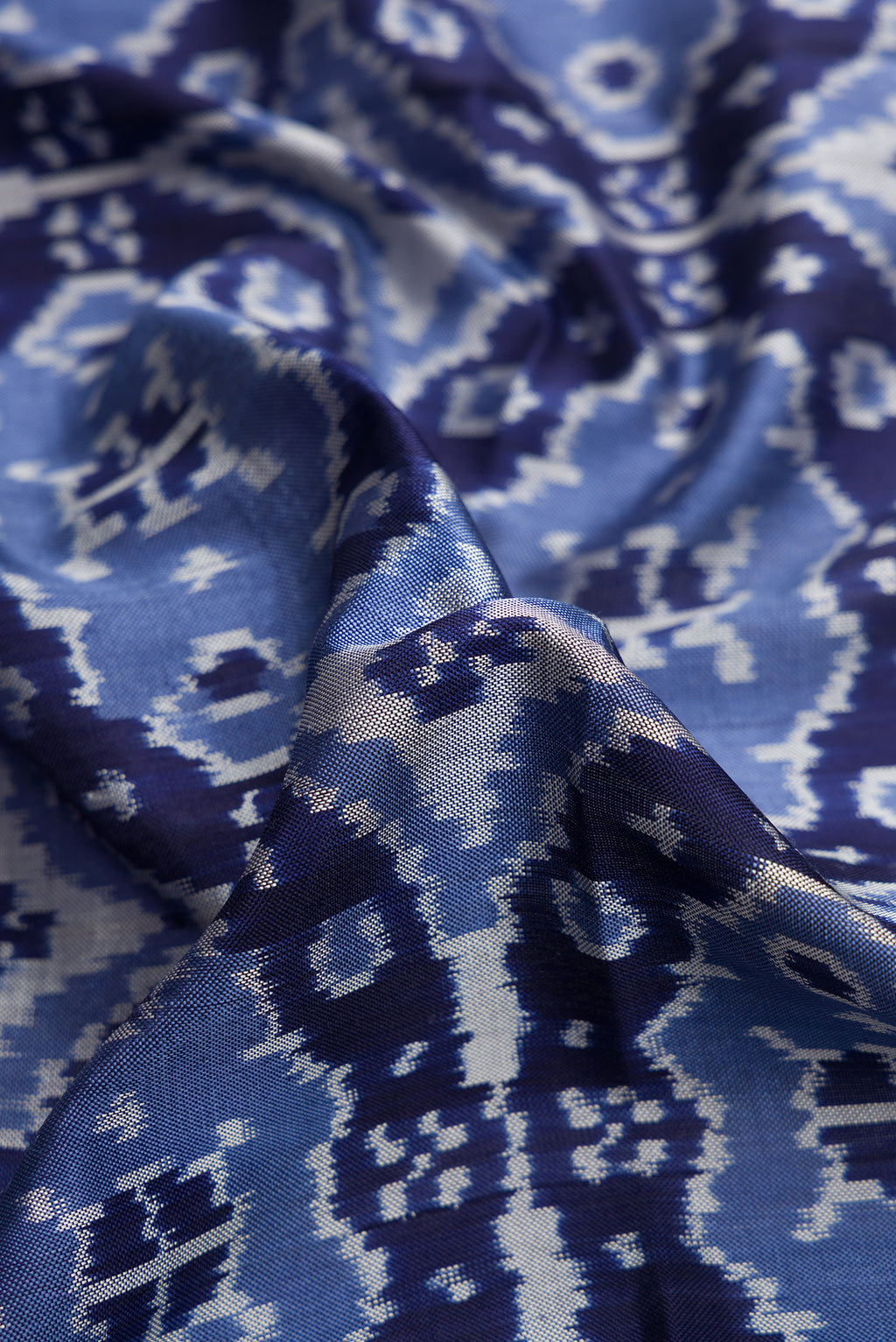 Close up of Navy Blue Dual Tone Double Ikat Saree with Ikat Print on the body and Plain Border.  displaying folds