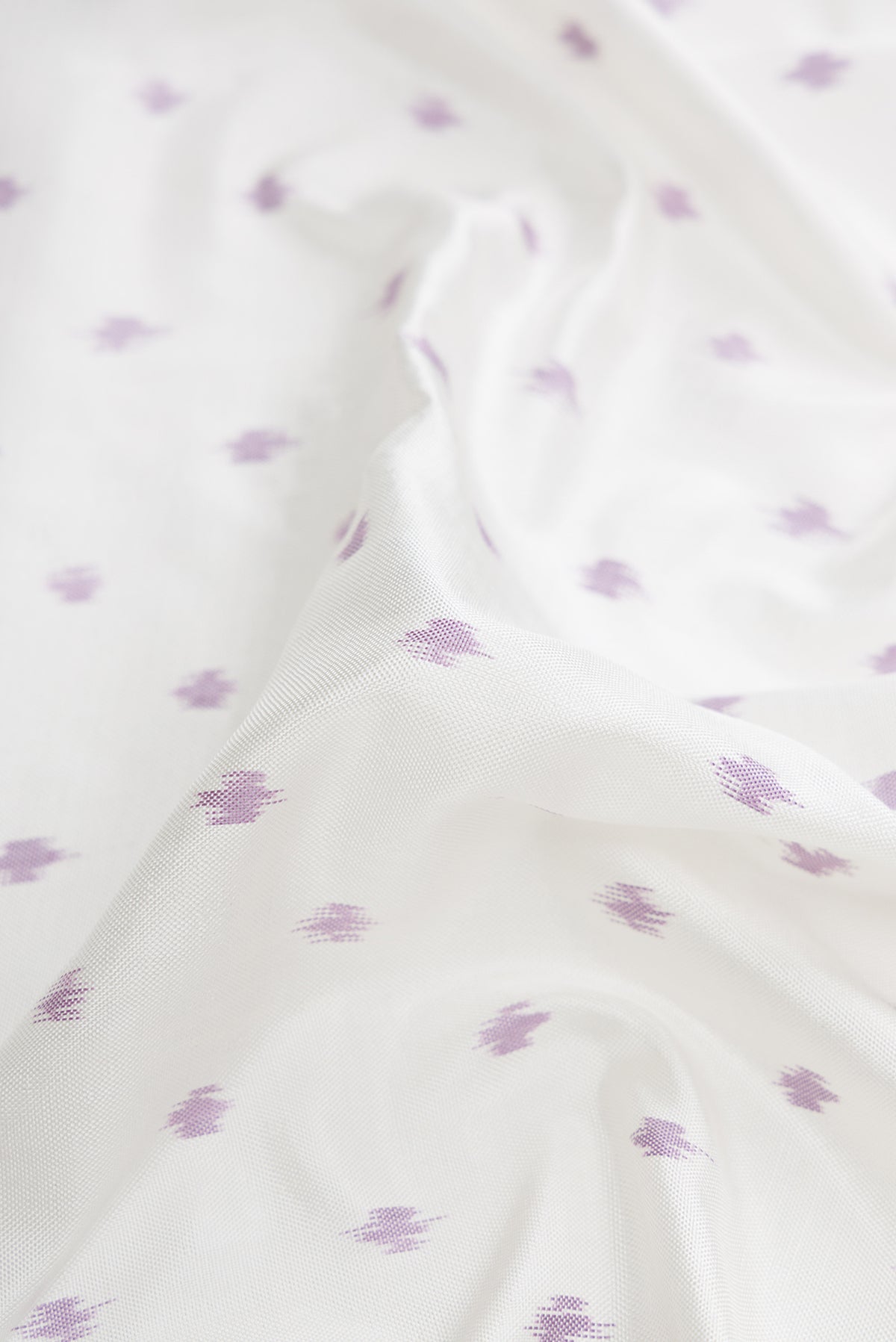 Close up of Off White Dual Tone Double Ikat Saree with Ikat Print on the body and Ikat Border.  displaying folds