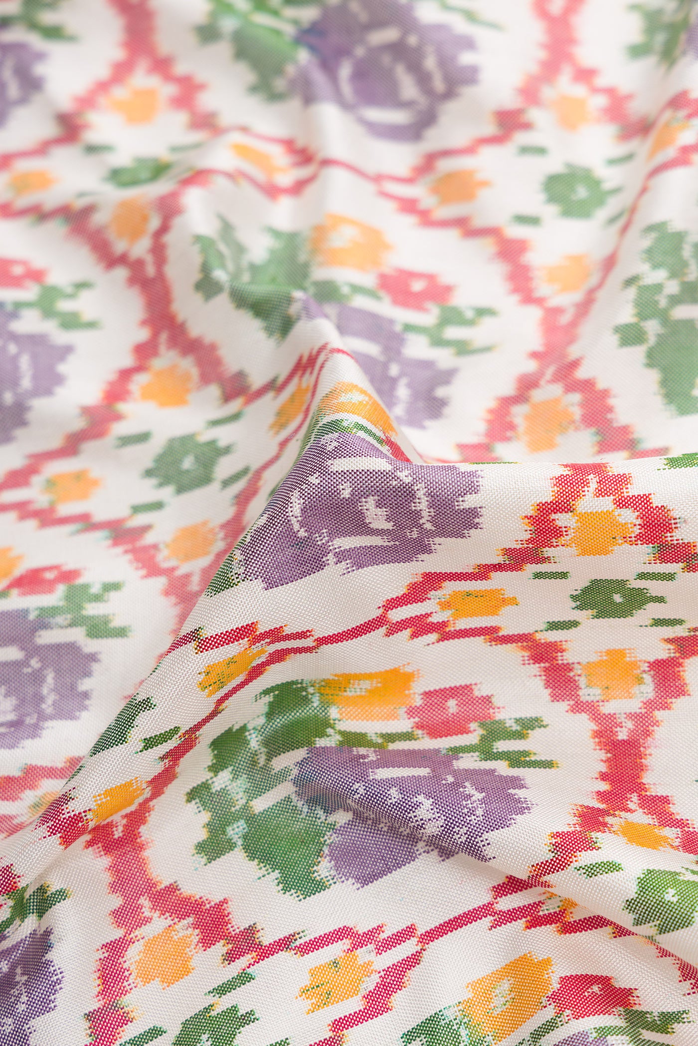 Close up of Off White Dual Tone Double Ikat Saree with Ikat Print on the body and Ikat Border.  displaying folds