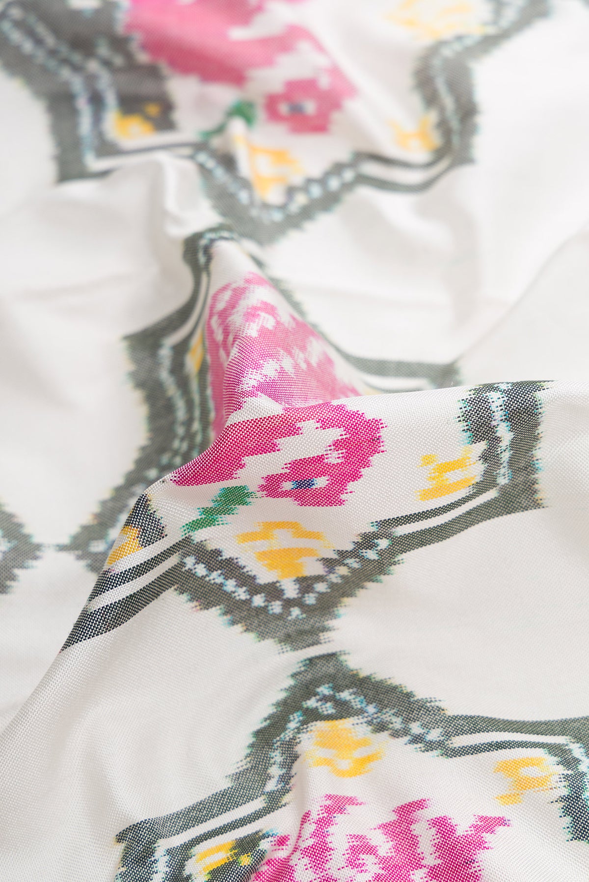 Close up of Off White Dual Tone Double Ikat Saree with Ikat Print on the body and Ikat Border.  displaying folds