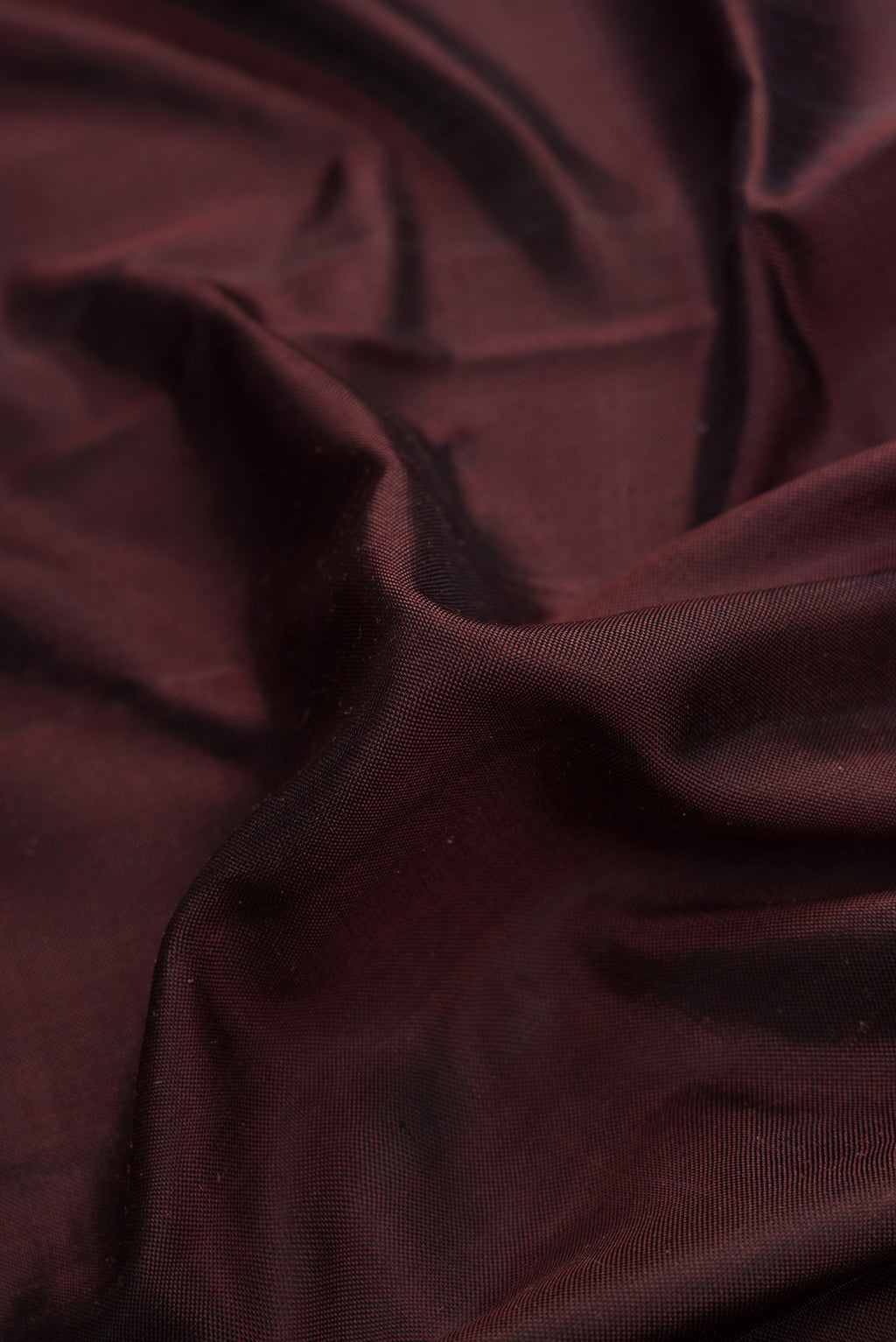 Close up of Brown Dual Tone Double Ikat Saree with Plain Body and Ikat Border.  displaying folds