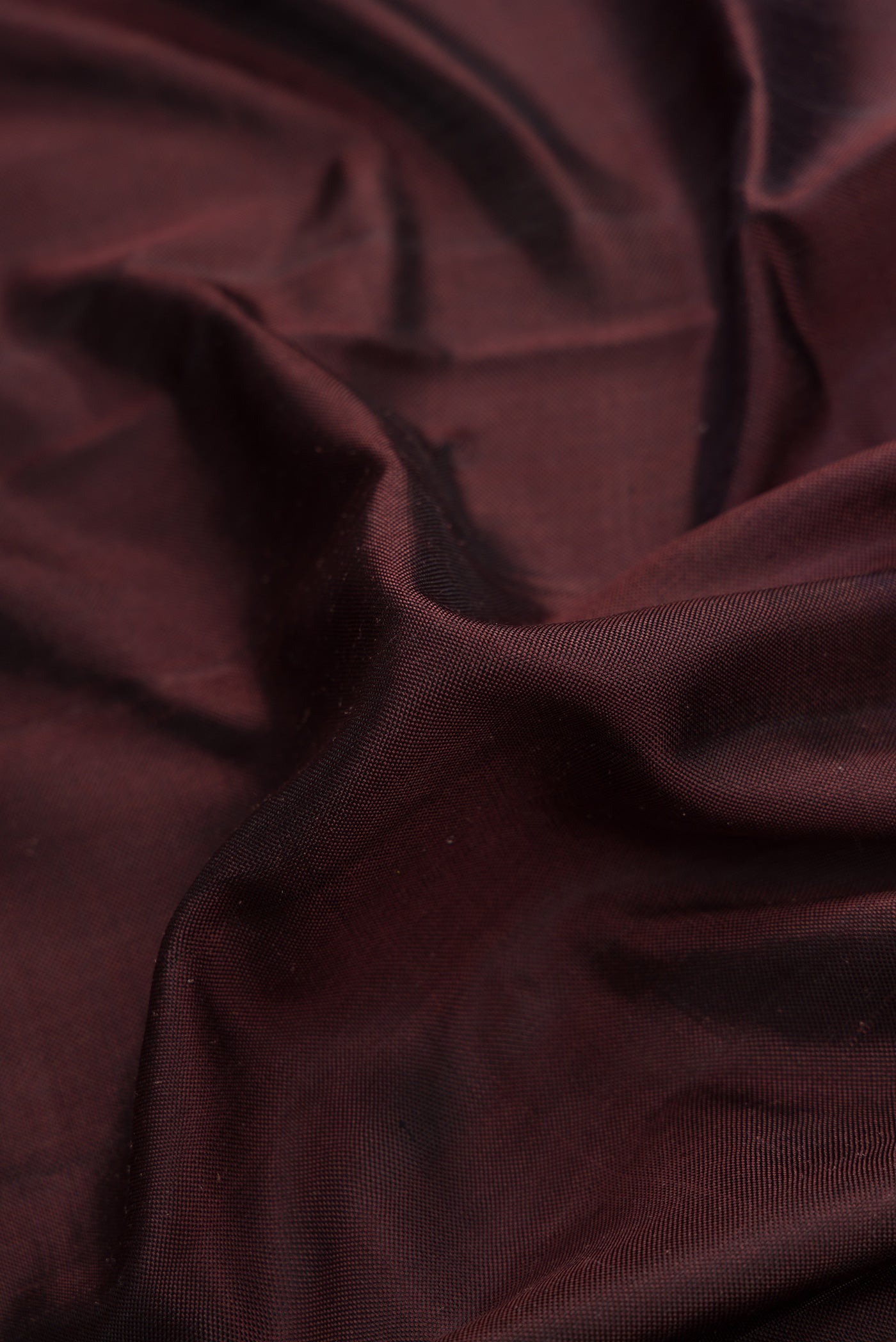 Close up of Brown Dual Tone Double Ikat Saree with Plain Body and Ikat Border.  displaying folds