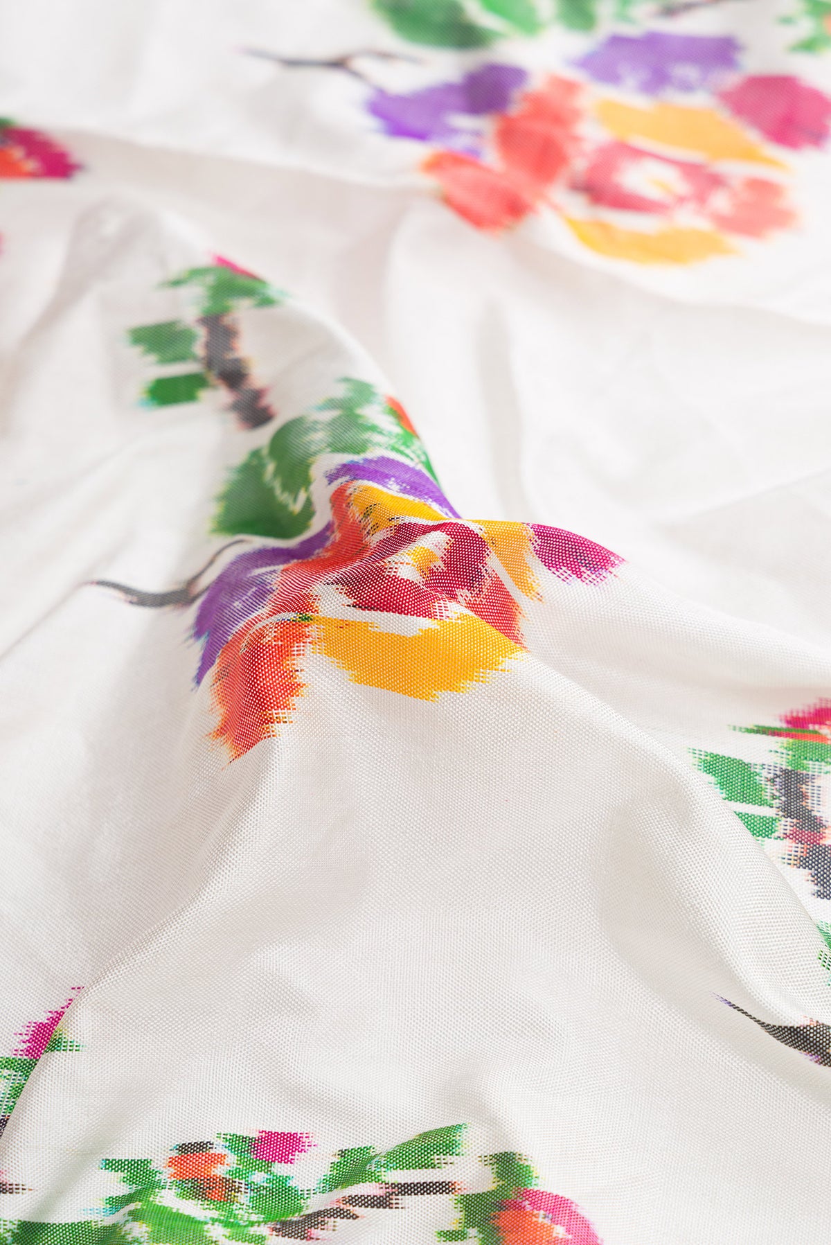 Close up of Off White Dual Tone Double Ikat Saree with Ikat Print on the body and Zari Border.  displaying folds