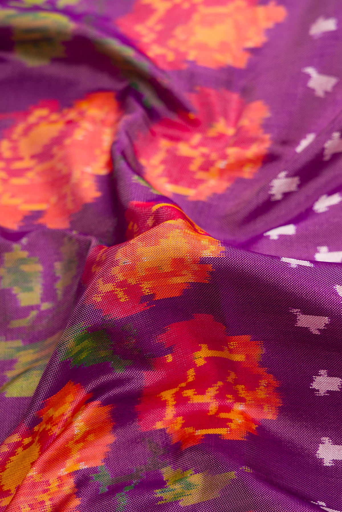 Close up of Purple Dual Tone Double Ikat Saree with Ikat Print on the body and Thread Border.  displaying folds