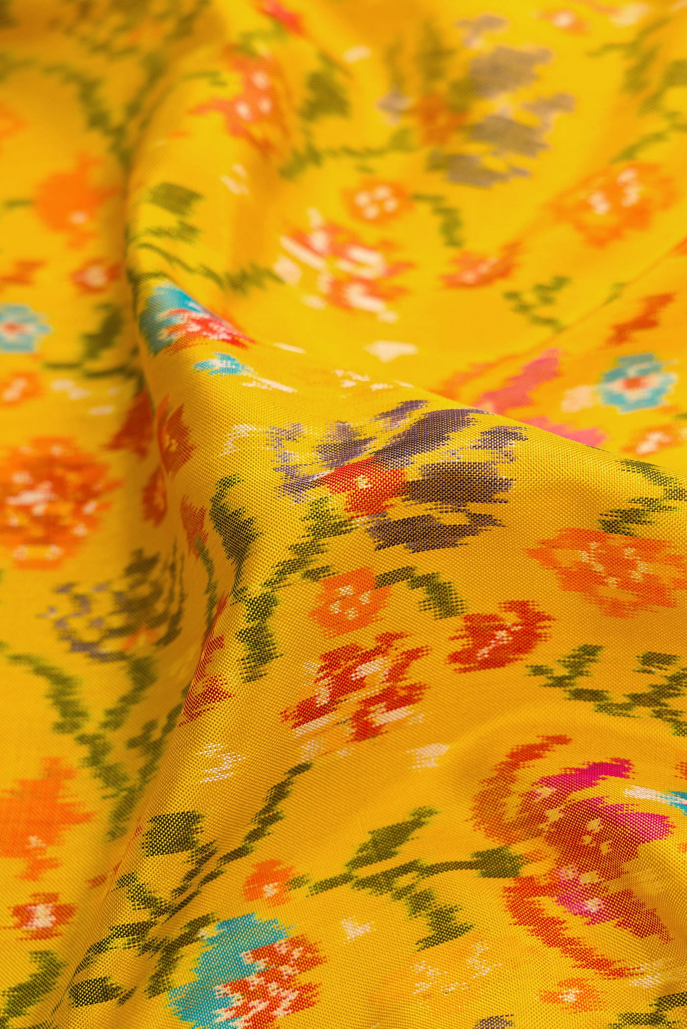 Close up of Yellow Dual Tone Double Ikat Saree with Ikat Print on the body and Plain Border.  displaying folds