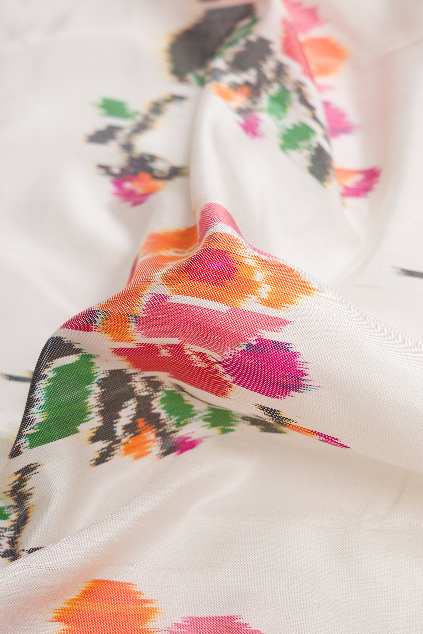 Close up of Off White Dual Tone Double Ikat Saree with Ikat Print on the body and Plain Border.  displaying folds