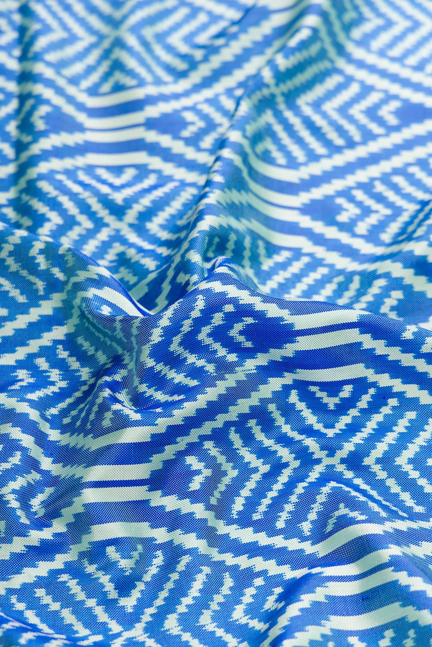 Close up of Sky Blue Dual Tone Double Ikat Saree with Ikat Print on the body and Thread Border.  displaying folds