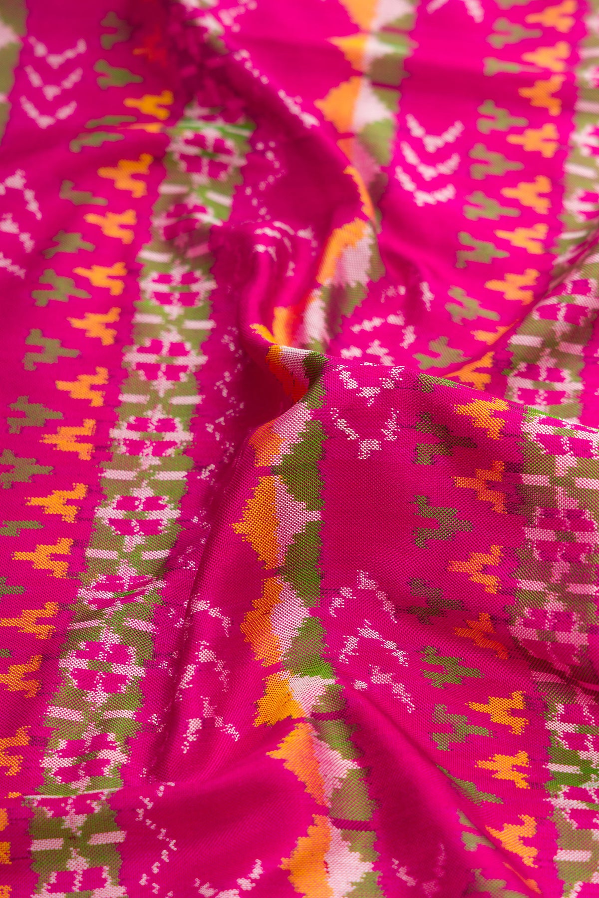 Close up of Pink Dual Tone Double Ikat Saree with Ikat Print on the body and Ikat Border.  displaying folds