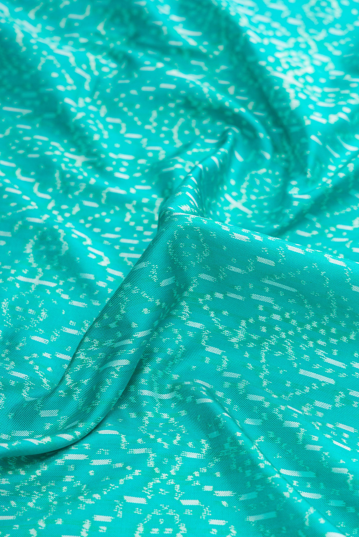 Close up of Sea Green Dual Tone Double Ikat Saree with Ikat Print on the body and Zari Border.  displaying folds