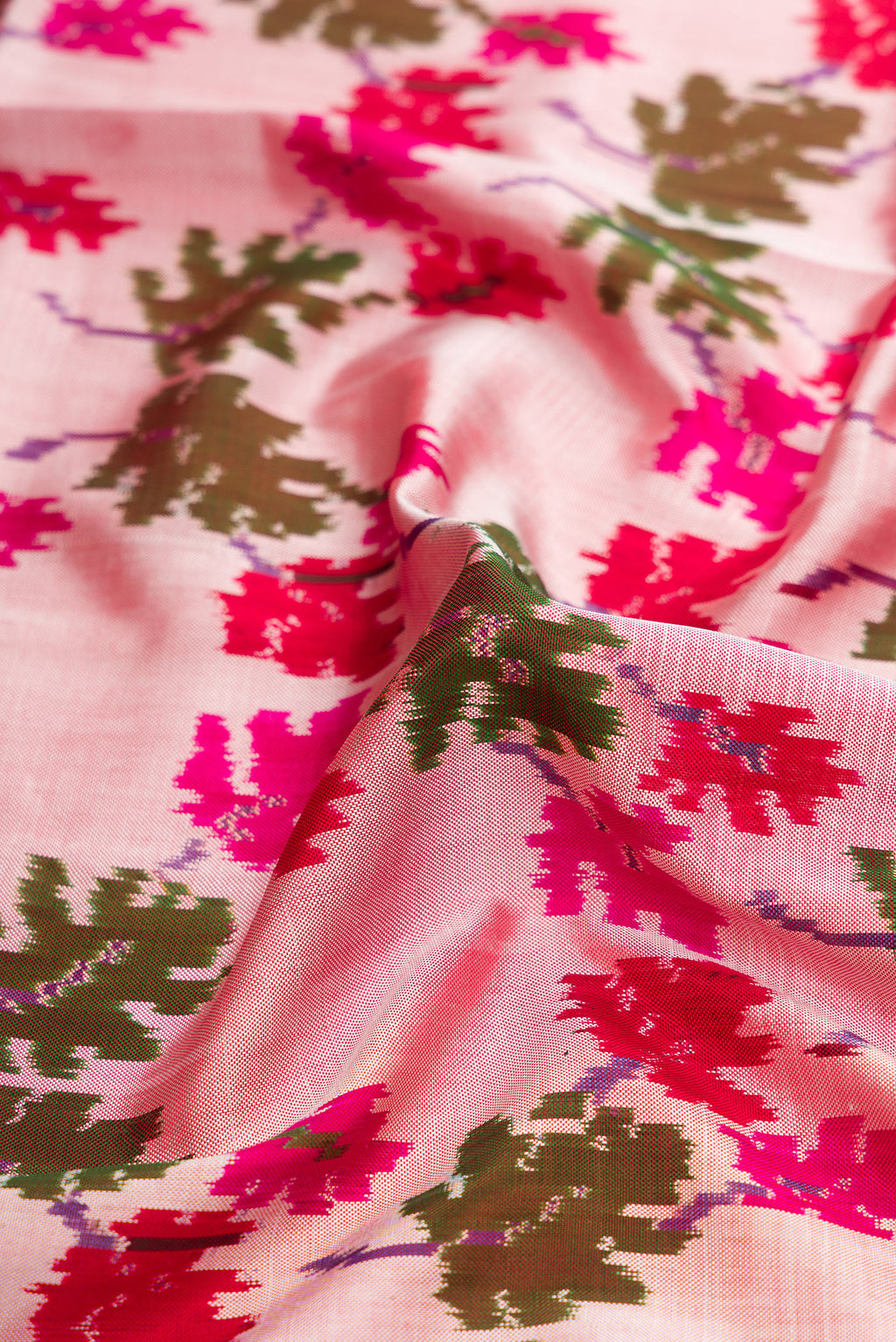 Close up of Pink Dual Tone Double Ikat Saree with Ikat Print on the body and Zari Border.  displaying folds
