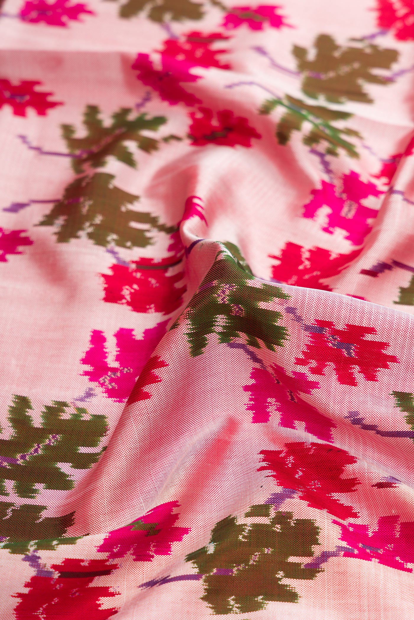Close up of Pink Dual Tone Double Ikat Saree with Ikat Print on the body and Zari Border.  displaying folds