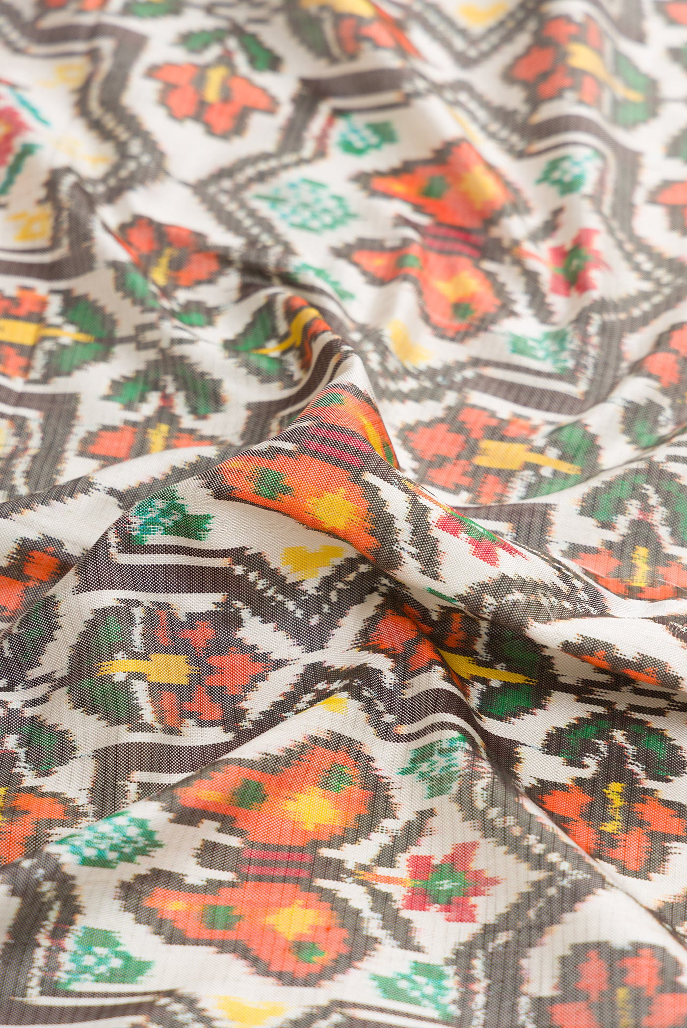 Close up of Beige Dual Tone Double Ikat Saree with Ikat Print on the body and Thread Border.  displaying folds