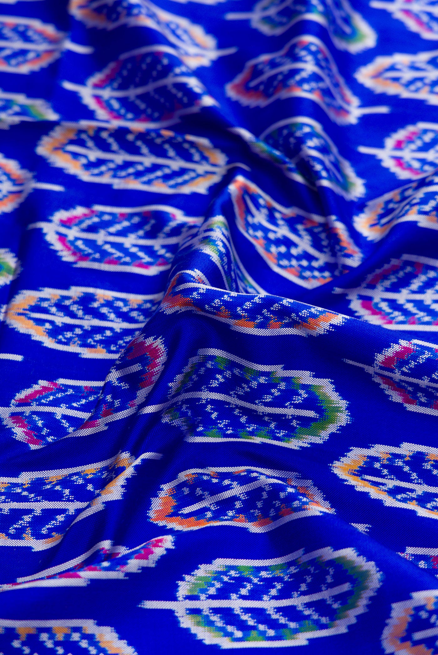 Close up of Royal Blue Dual Tone Double Ikat Saree with Ikat Print on the body and Thread Border.  displaying folds