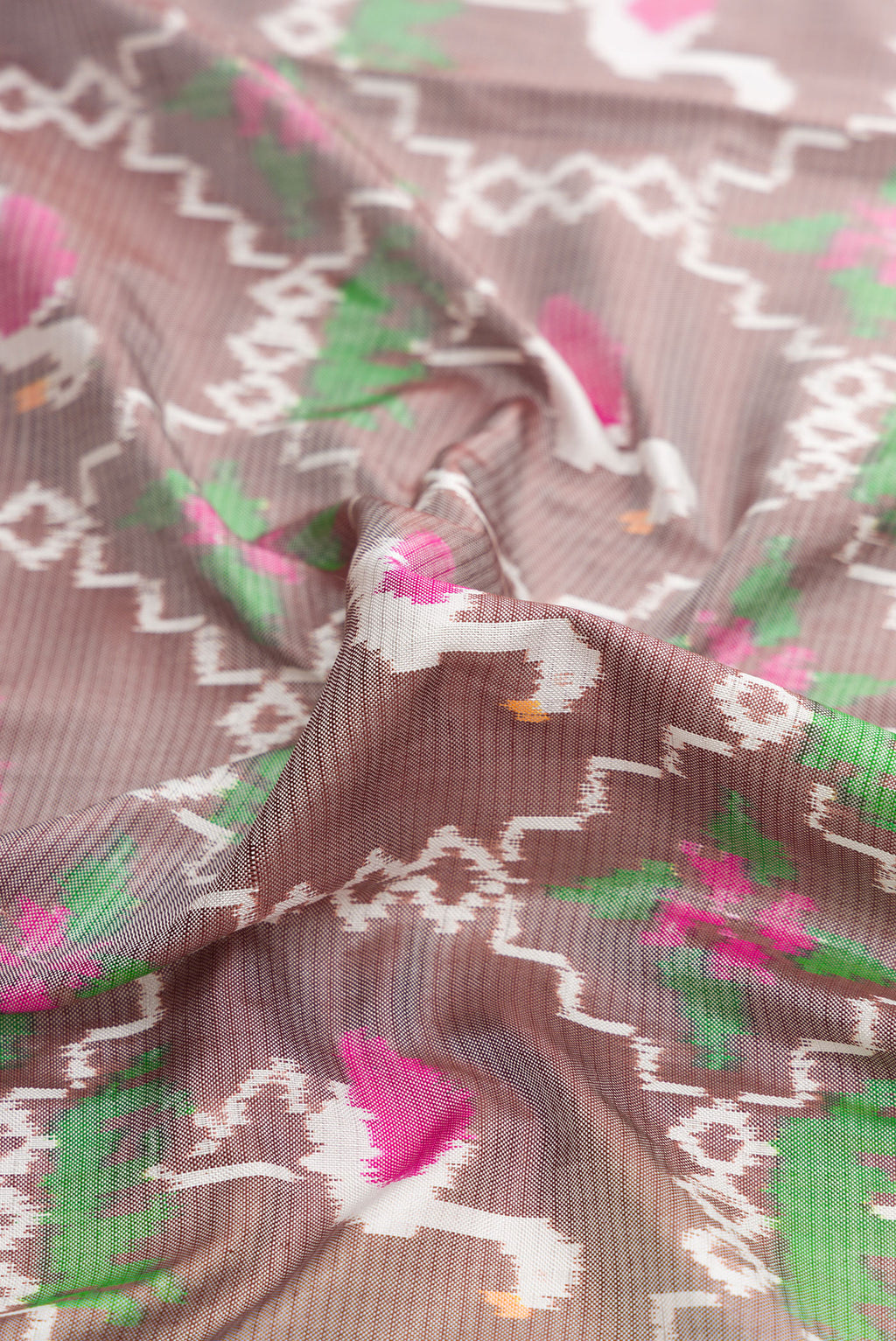 Close up of Grey Dual Tone Double Ikat Saree with Ikat Print on the body and Thread Border.  displaying folds