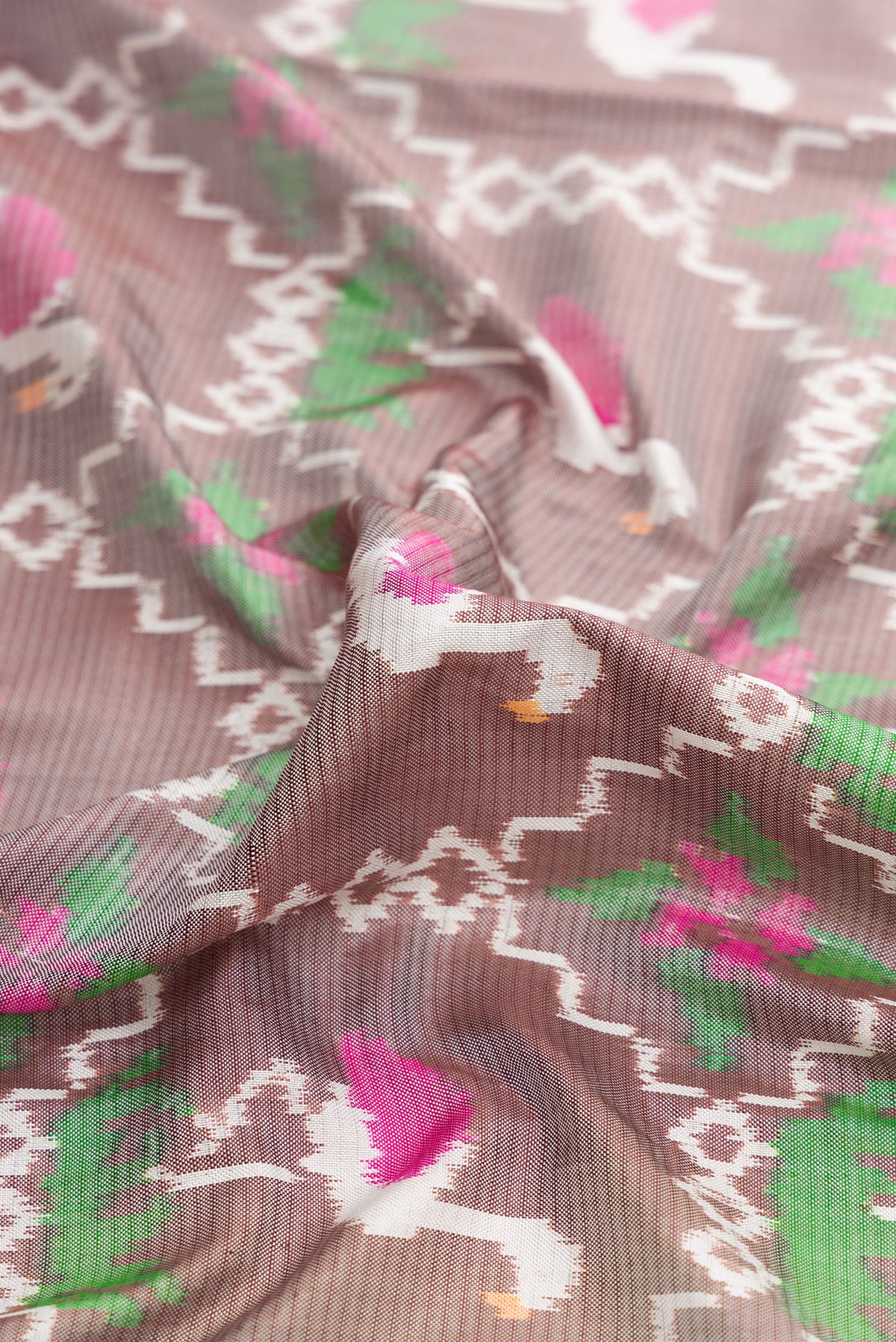 Close up of Grey Dual Tone Double Ikat Saree with Ikat Print on the body and Thread Border.  displaying folds