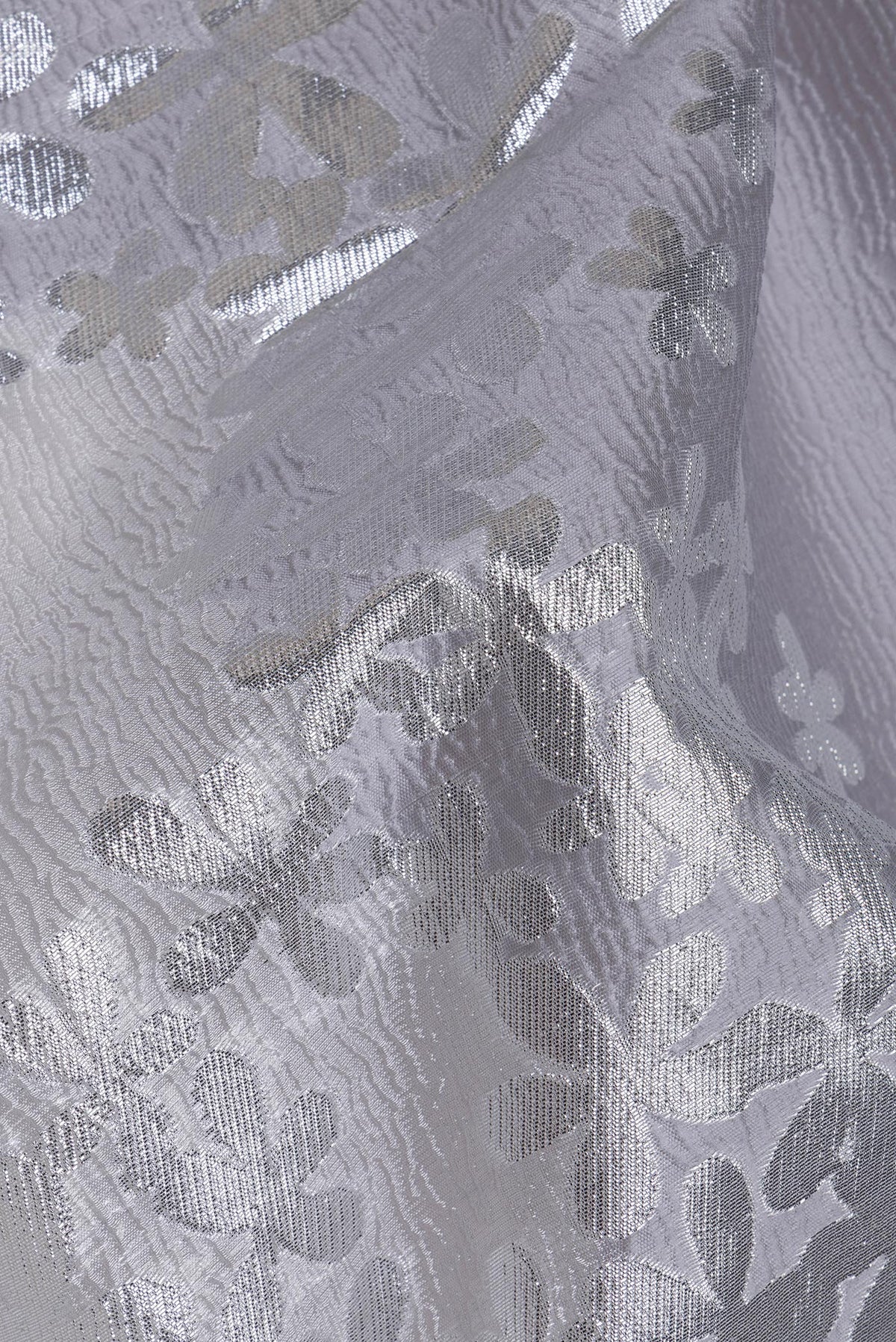 Close up of Silver Organza Silk Saree with Zari Brocade on the body and Embroidery Border.  displaying folds
