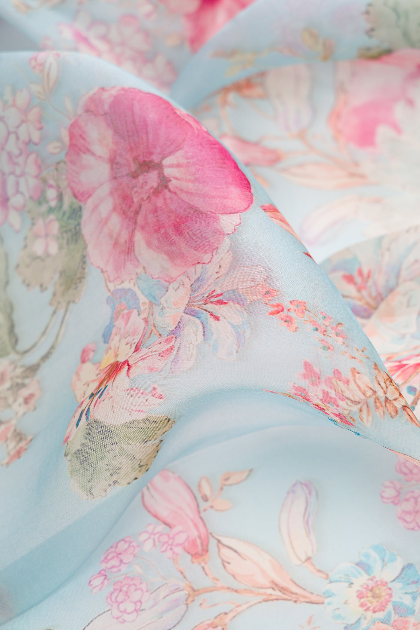 Close up of Sky Blue Dual Tone Organza Silk Saree with Printed design on the body and Zari And Thread Border.  displaying folds