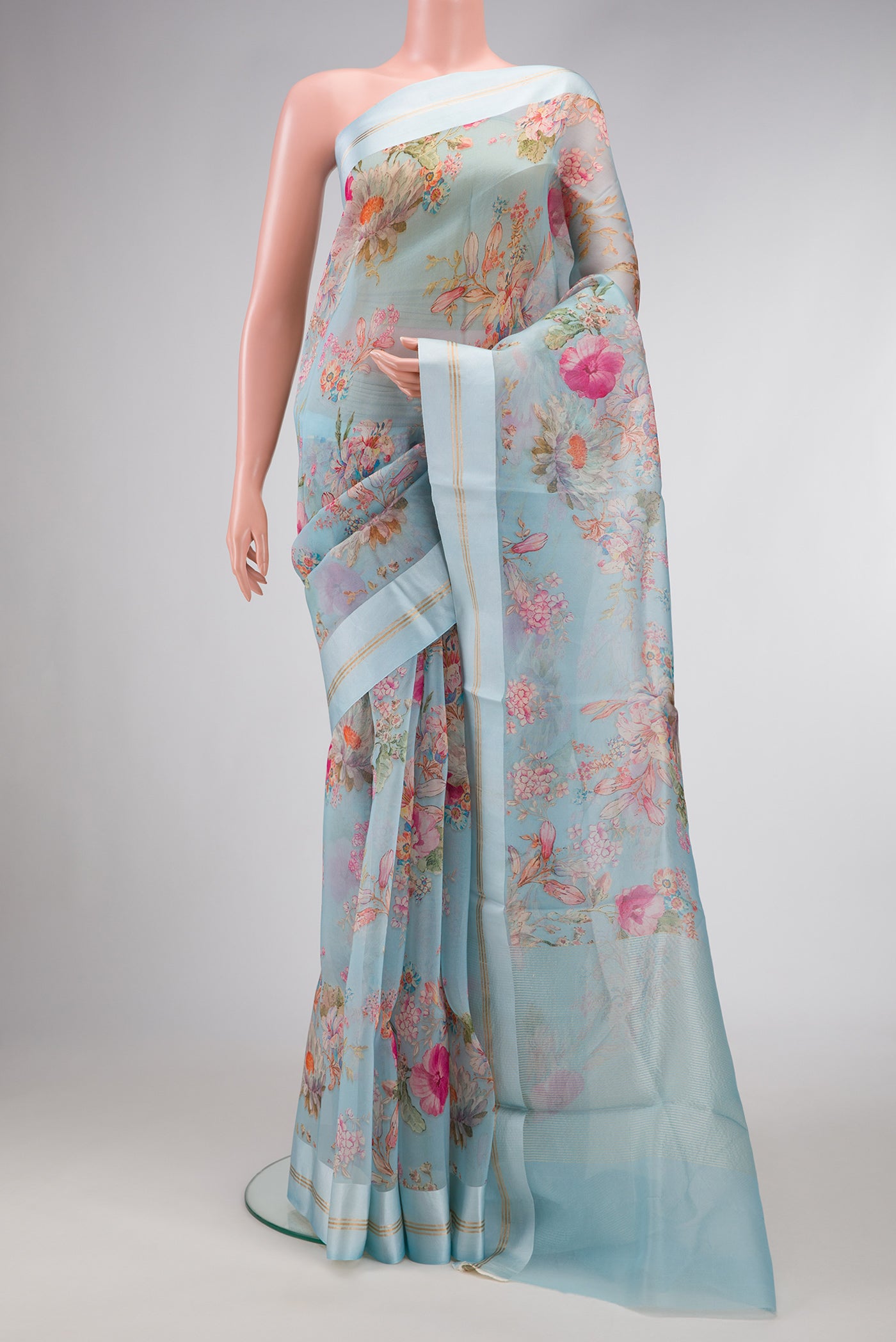 Sky Blue Dual Tone Organza Silk Saree with Printed design on the body and Zari And Thread Border.  displayed on a mannequin