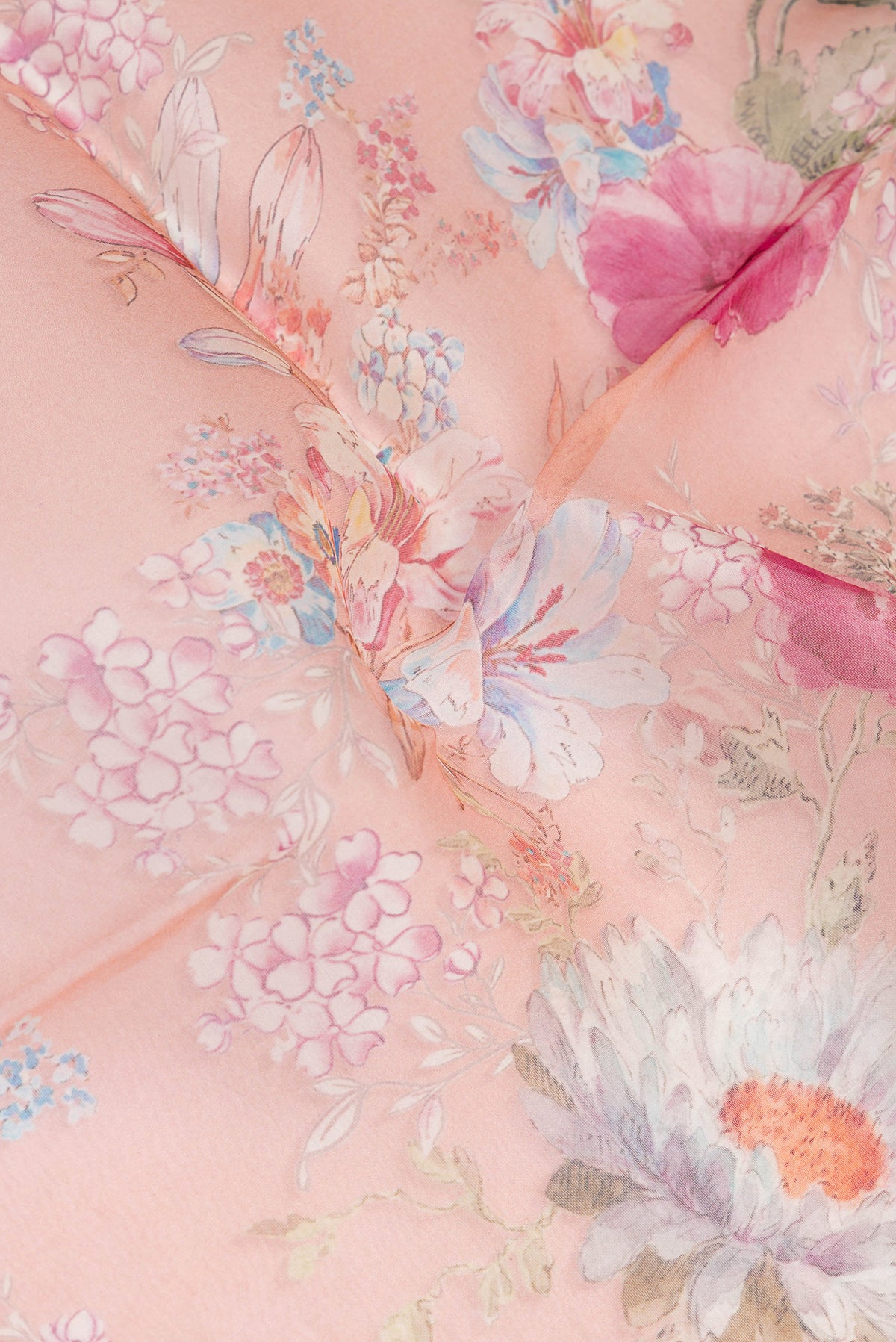 Close up of Golden Peach Organza Silk Saree with Floral Print on the body and Satin Border.  displaying folds