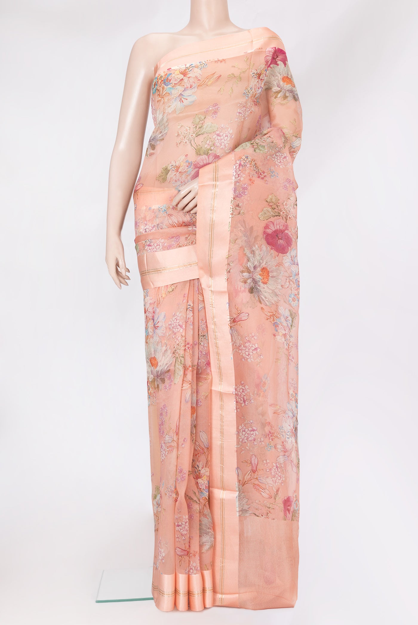 Golden Peach Organza Silk Saree with Floral Print on the body and Satin Border.  displayed on a mannequin
