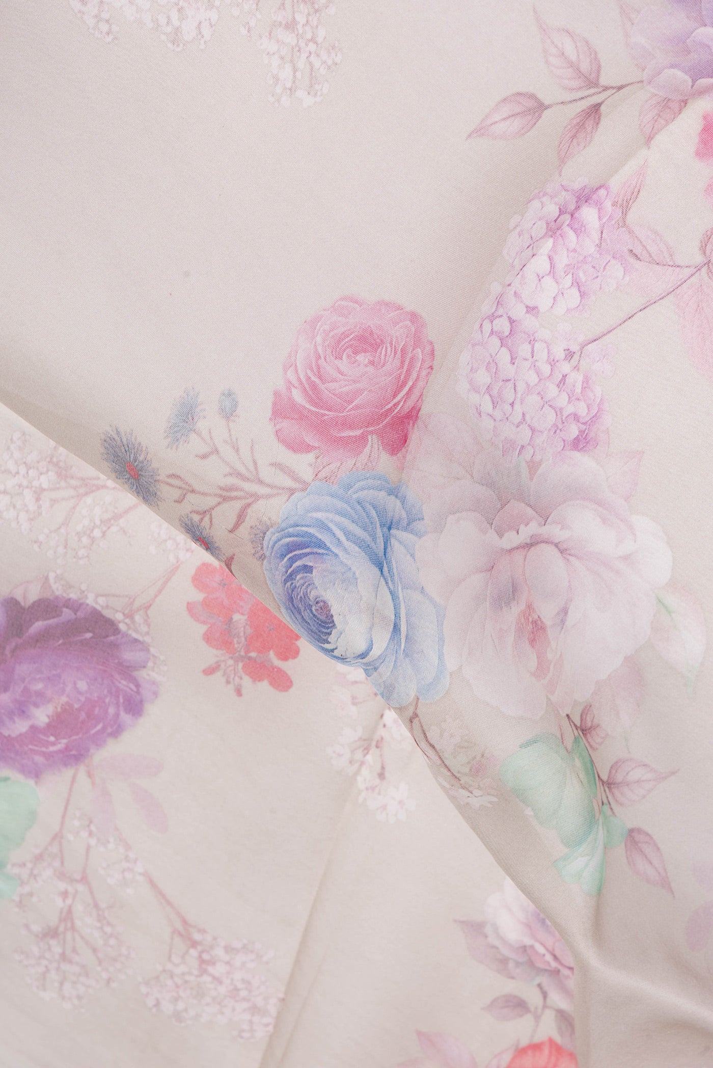 Close up of Beige Organza Silk Saree with Floral Print on the body and Satin Border.  displaying folds