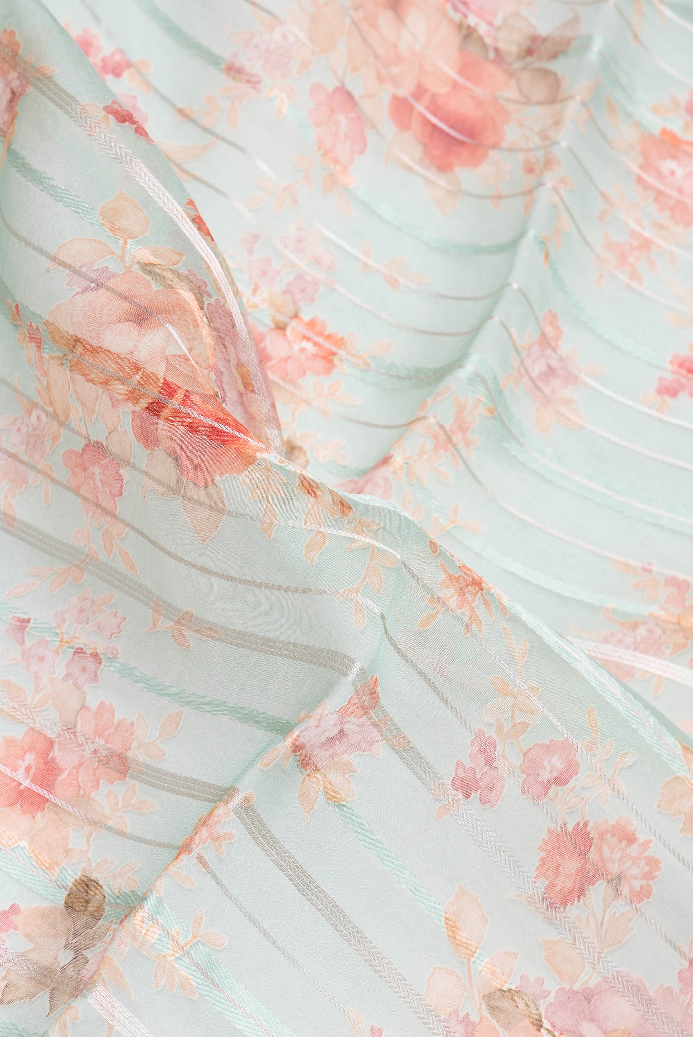 Close up of Sea Green Organza Silk Saree with Stripes on the body and Thread Border.  displaying folds