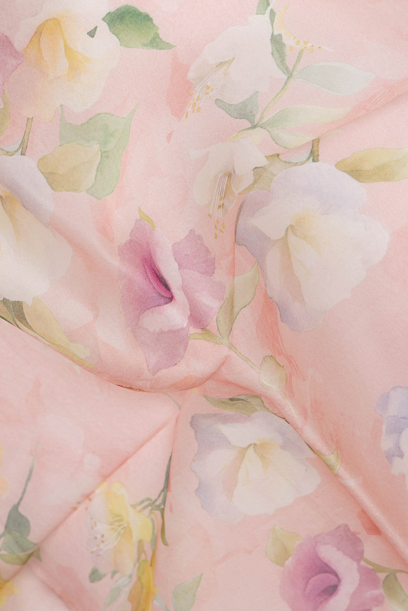 Close up of Rose Gold Organza Silk Saree with Floral Print on the body and Satin Border.  displaying folds