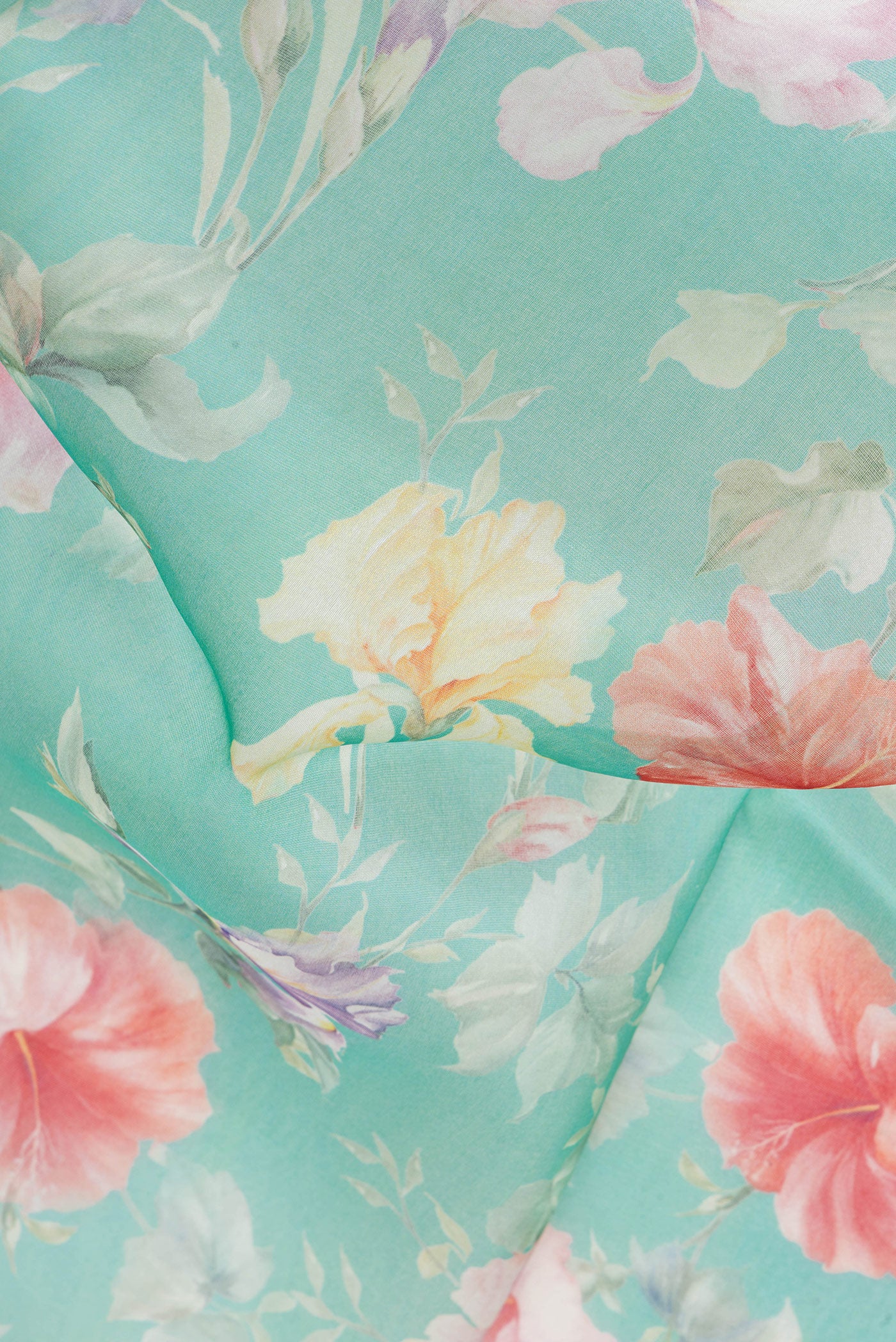 Close up of Turquoise Organza Silk Saree with Floral Print on the body and Plain Border.  displaying folds