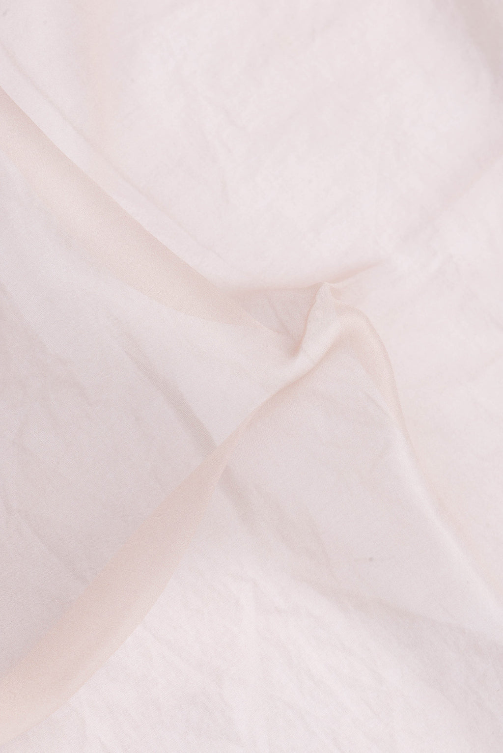 Close up of Rose Gold Dual Tone Organza Silk Saree with Plain Body and Printed Border.  displaying folds