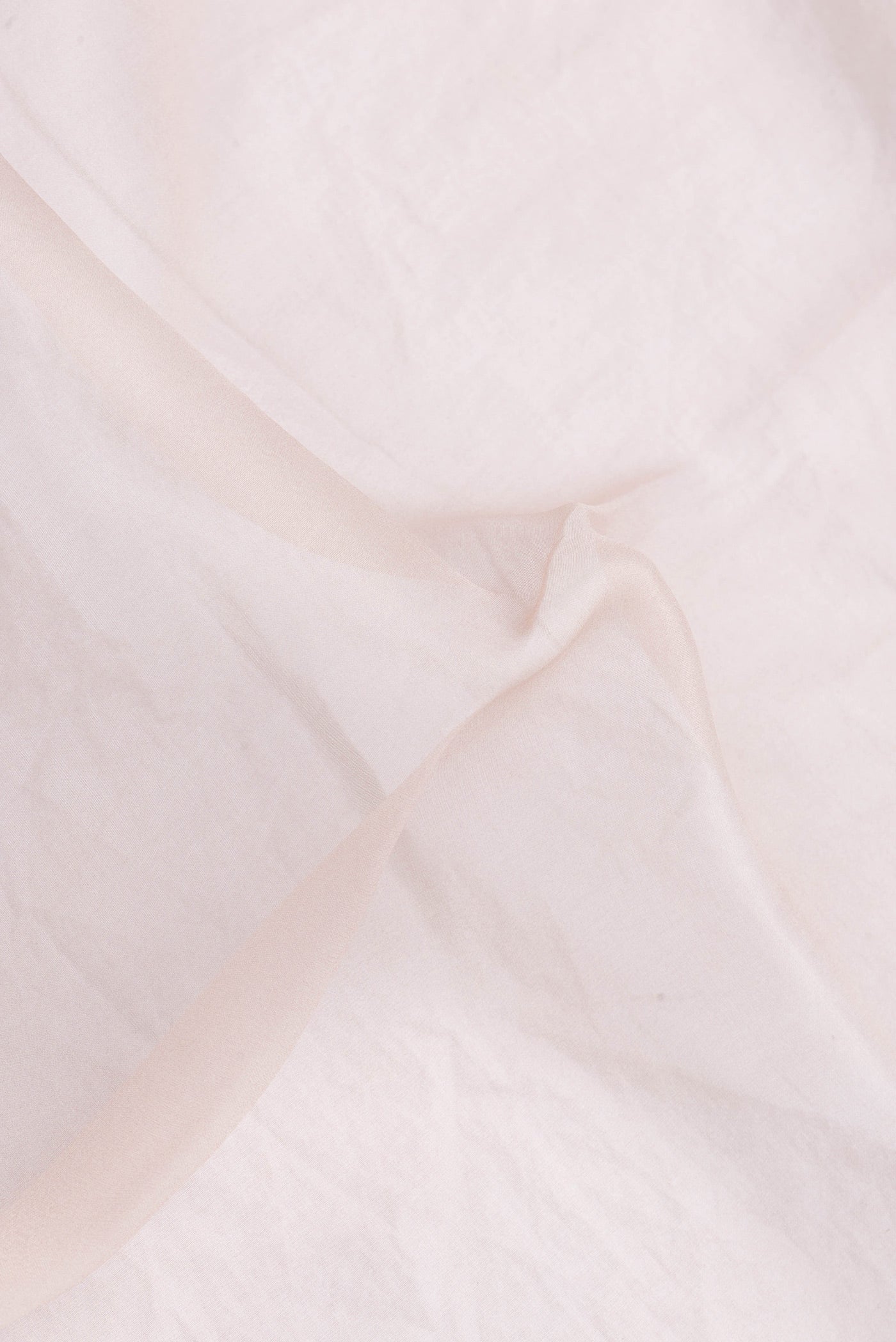 Close up of Rose Gold Dual Tone Organza Silk Saree with Plain Body and Printed Border.  displaying folds